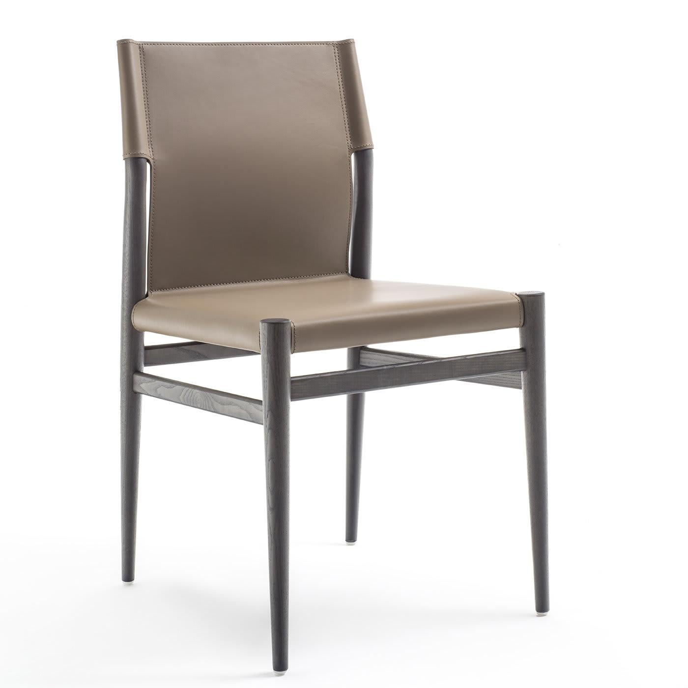La seduta e lo schienale della sedia Ledermann sono uniti e completamente rivestiti in pelle color taupe. La struttura e le quattro gambe affusolate e coniche sono realizzate in legno di frassino grigio. Il suo minimalismo robusto e dagli spigoli