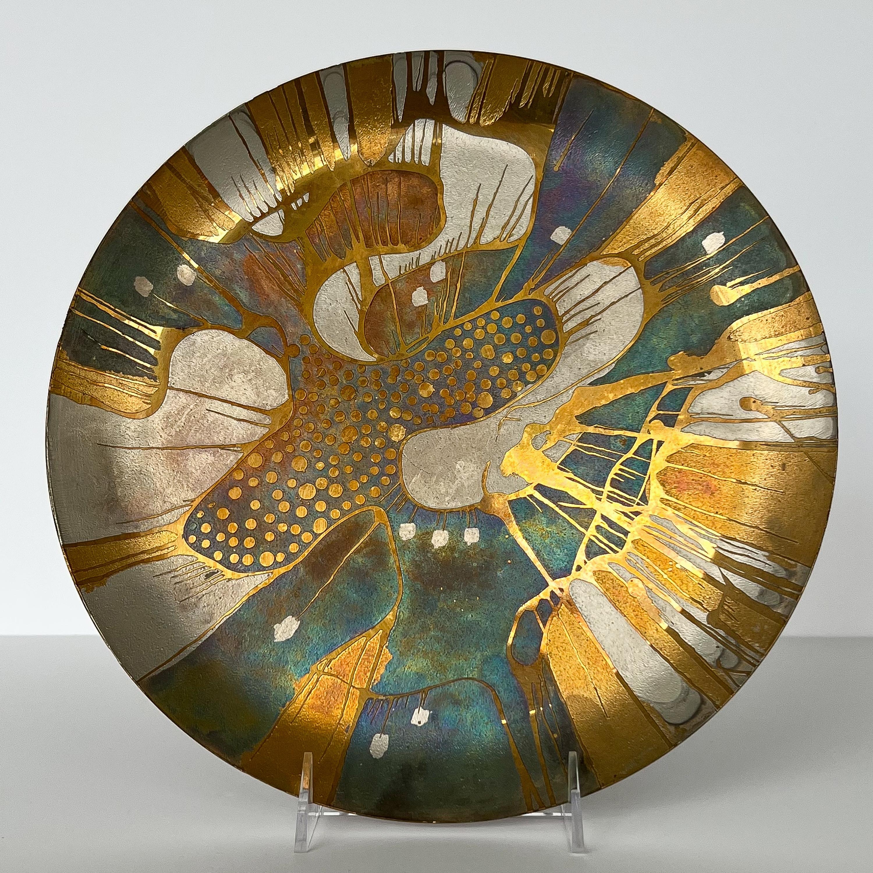 A vintage Lee Barnes Peck handcrafted abstract brass and multi colored copper plate, circa 1970s. This mixed metal plate features gold, silver, blue, purple and copper colors. The decorative charger is etched and plated in a stunning and mesmerizing
