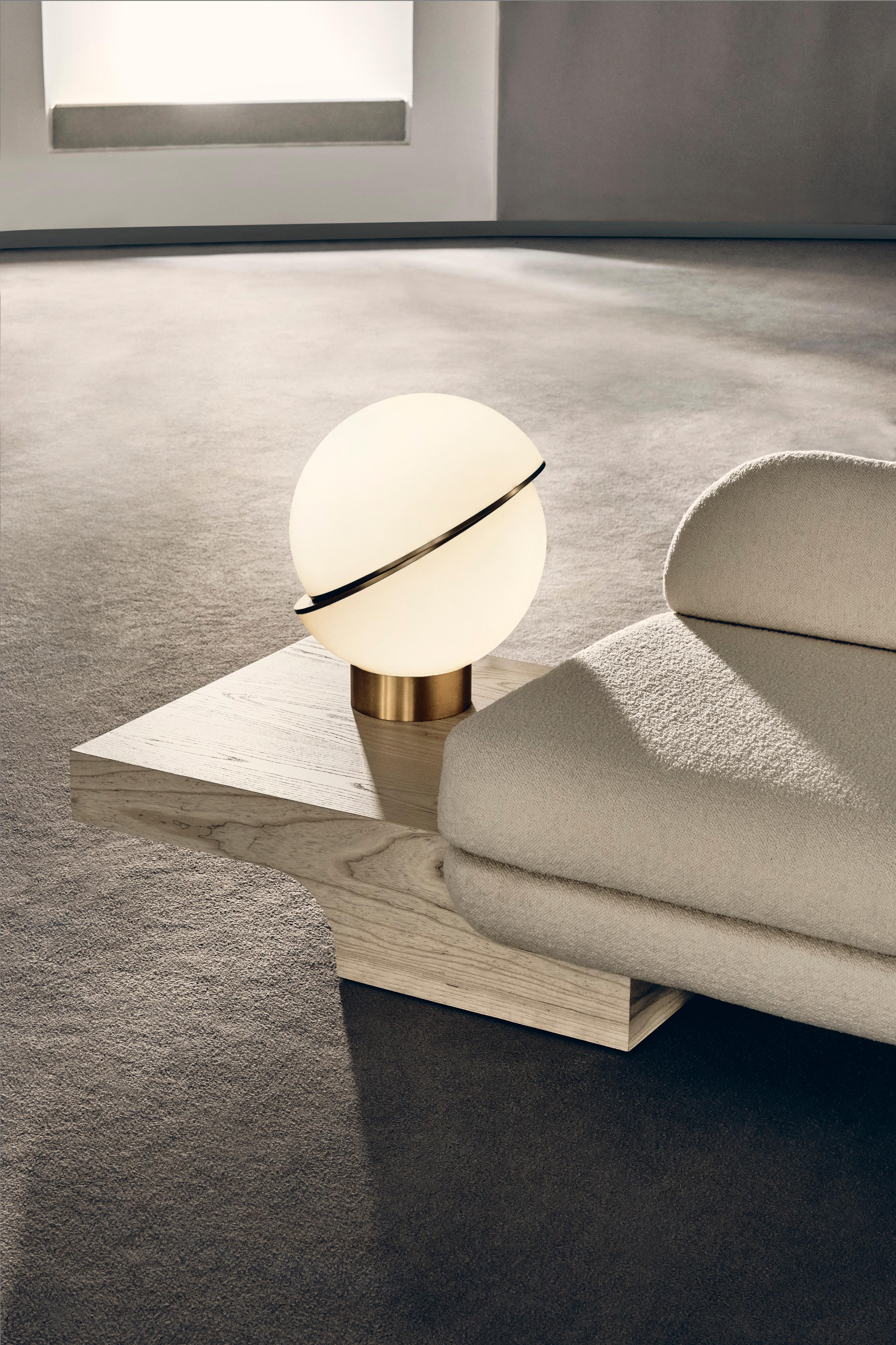 LAMPE DE TABLE À CROISSANT
Sphère lumineuse coupée en deux pour laisser apparaître un bandeau en laiton brossé en forme de croissant, Crescent allie harmonieusement le solide et l'opaque.

SPÉCIFICATIONS TECHNIQUES
Dimensions : H 48.5cm x Dia 38cm /