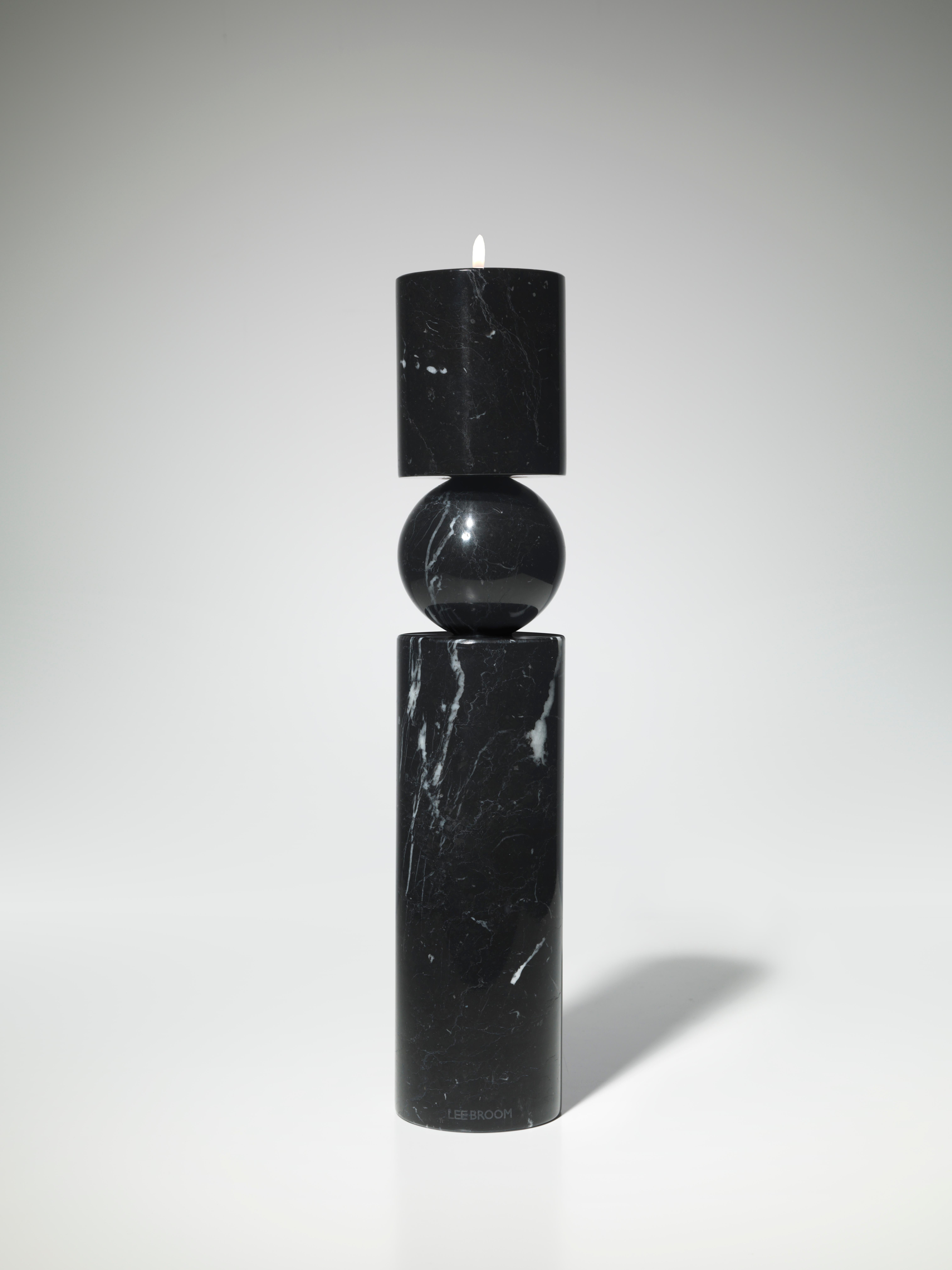 A play on the concept of pivots and supports, Fulcrum is a sculptural and monolithic candlestick whose cylindrical stem appears to balance on a central sphere. 

Includes large clear cup tealight candle.