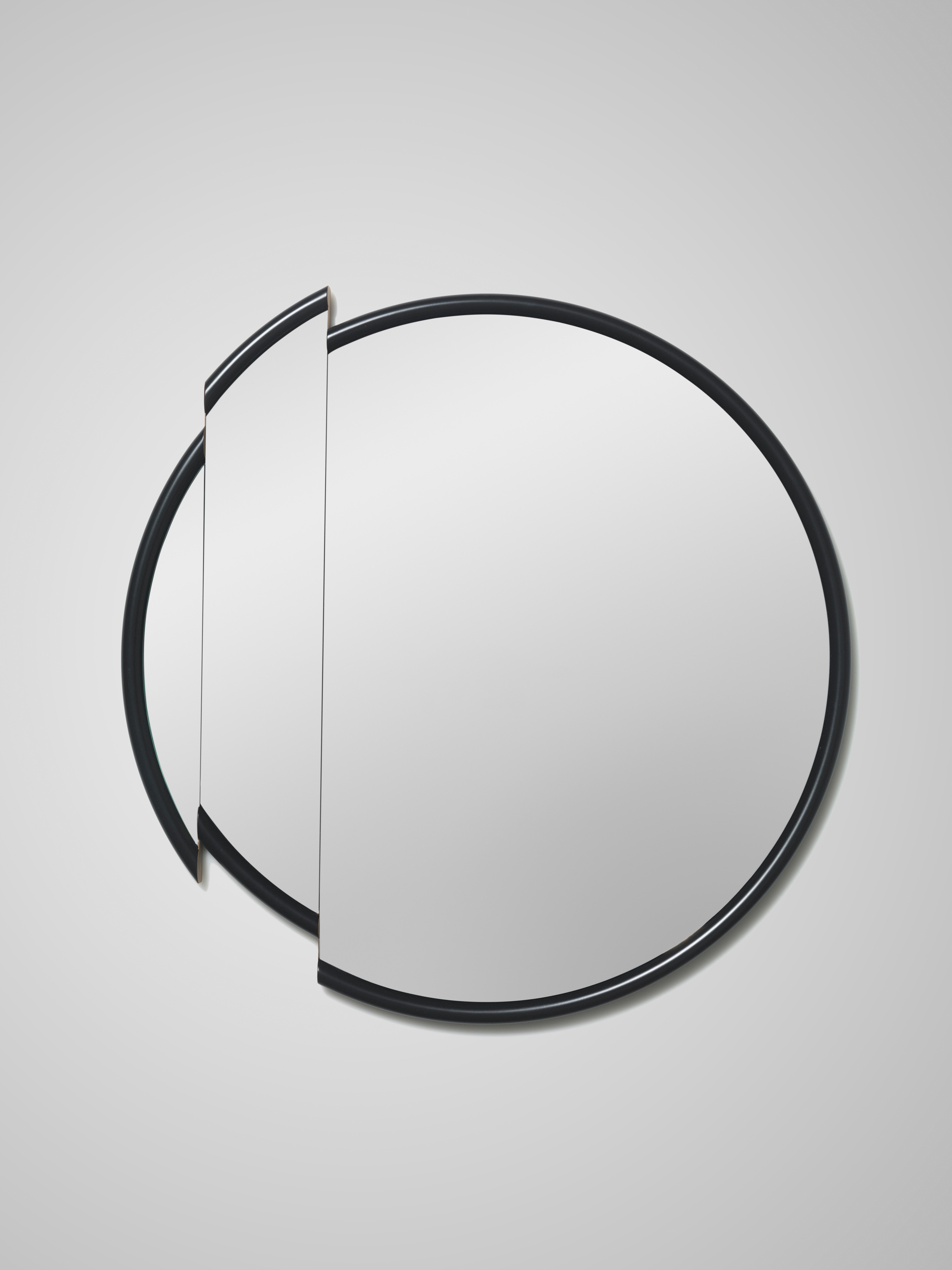 A precision cut slice, shifted from its original position reveals an oak trimmed section of the black frame on Split Mirror.

