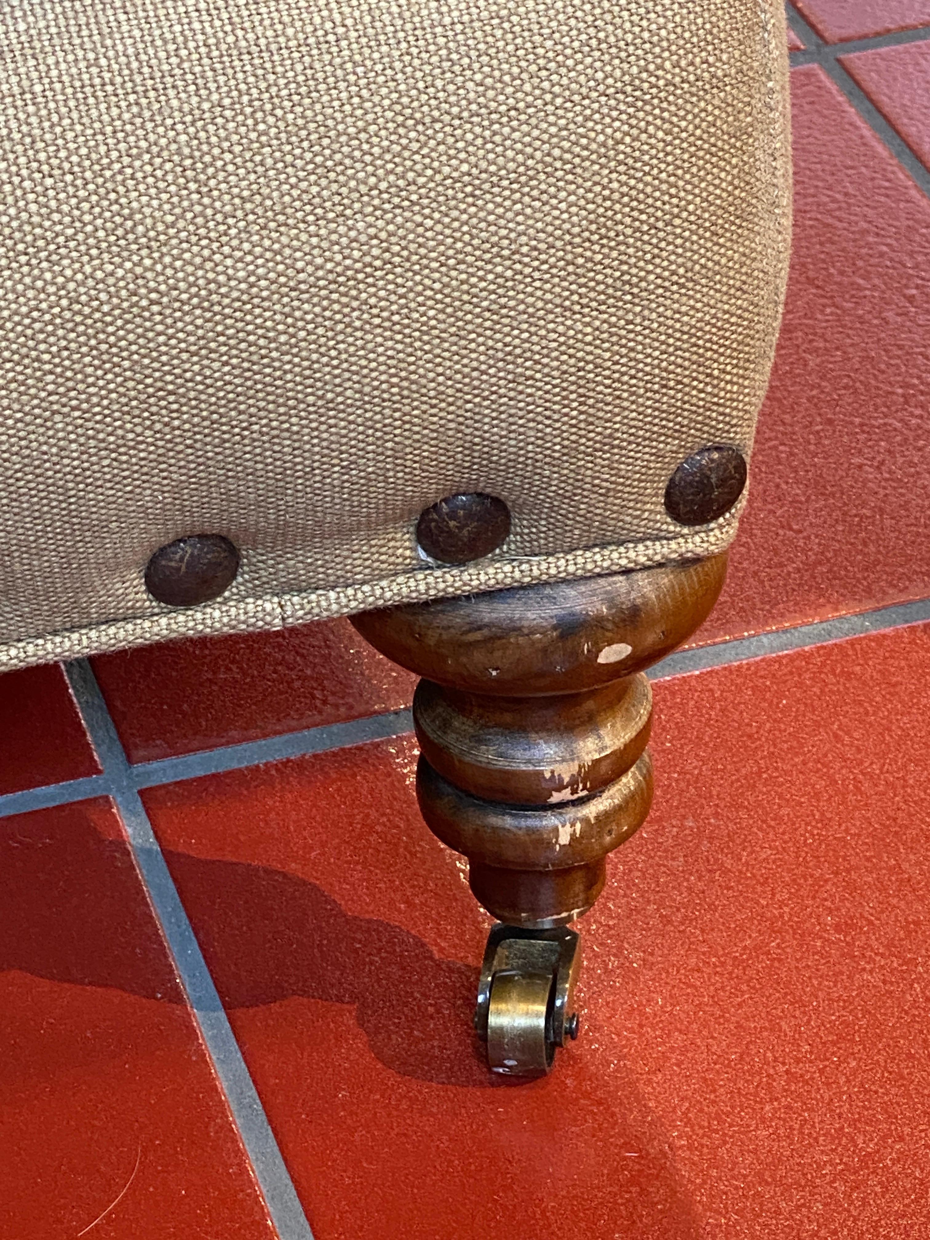 Lee Industries English arm sofa. Tan linen fabric with charcoal pillows and brass studs. One side of left cushion has a bleach stain, other side is good. Wood on legs has some wear. Stunning couch with gorgeous fabric.