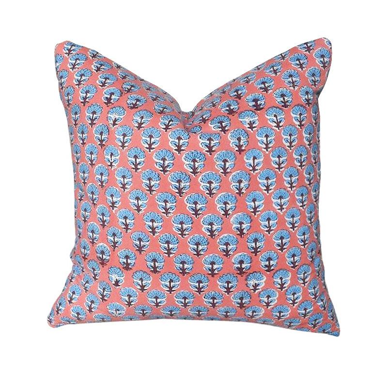 Bring a taste of the orient to any space with one of our custom-created Indian block print pillows. Each pillow is made of soft cotton and hand block printed by our artisans in India. Set on a bright coral pink background, blue blocked flowers flank