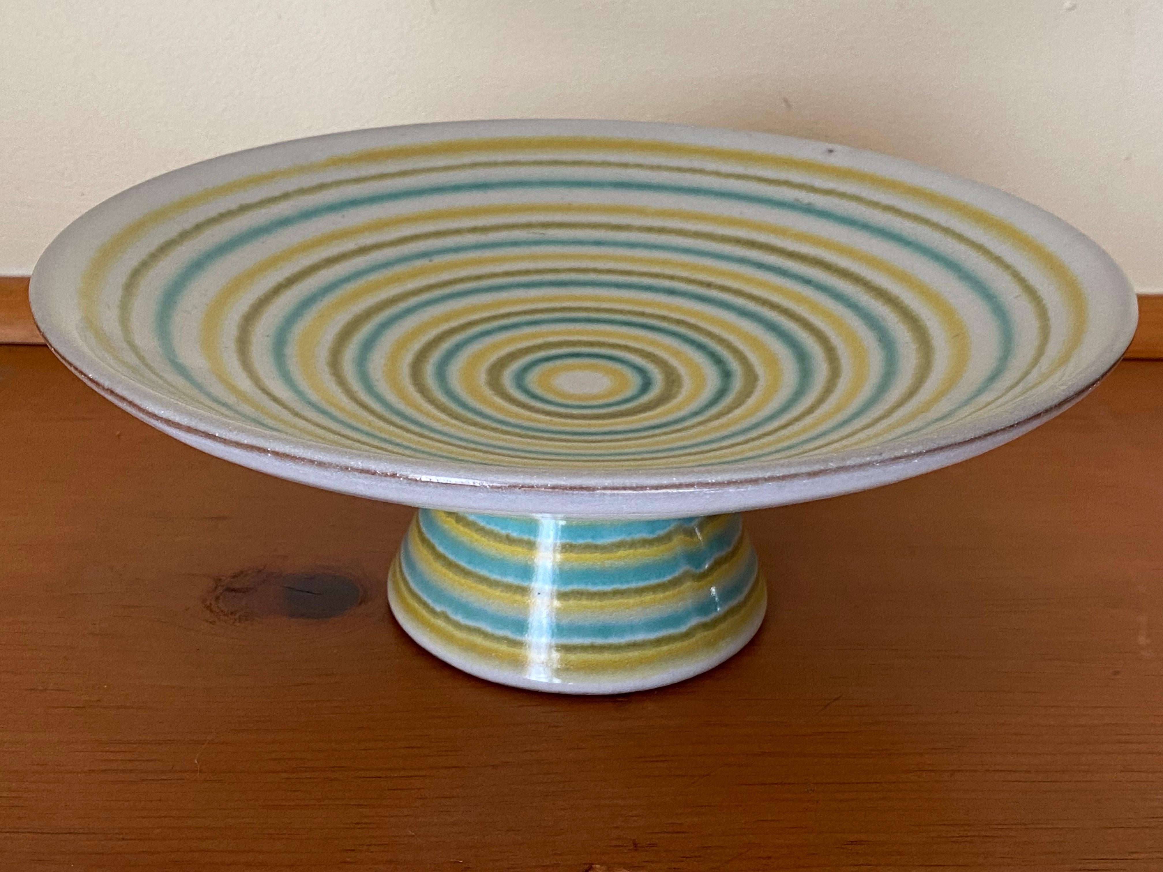 Ciotola con piede di Lee Rosen per Design Technics del 1960, con un disegno dinamico di anelli concentrici di ocra, verde oliva e turchese. 
