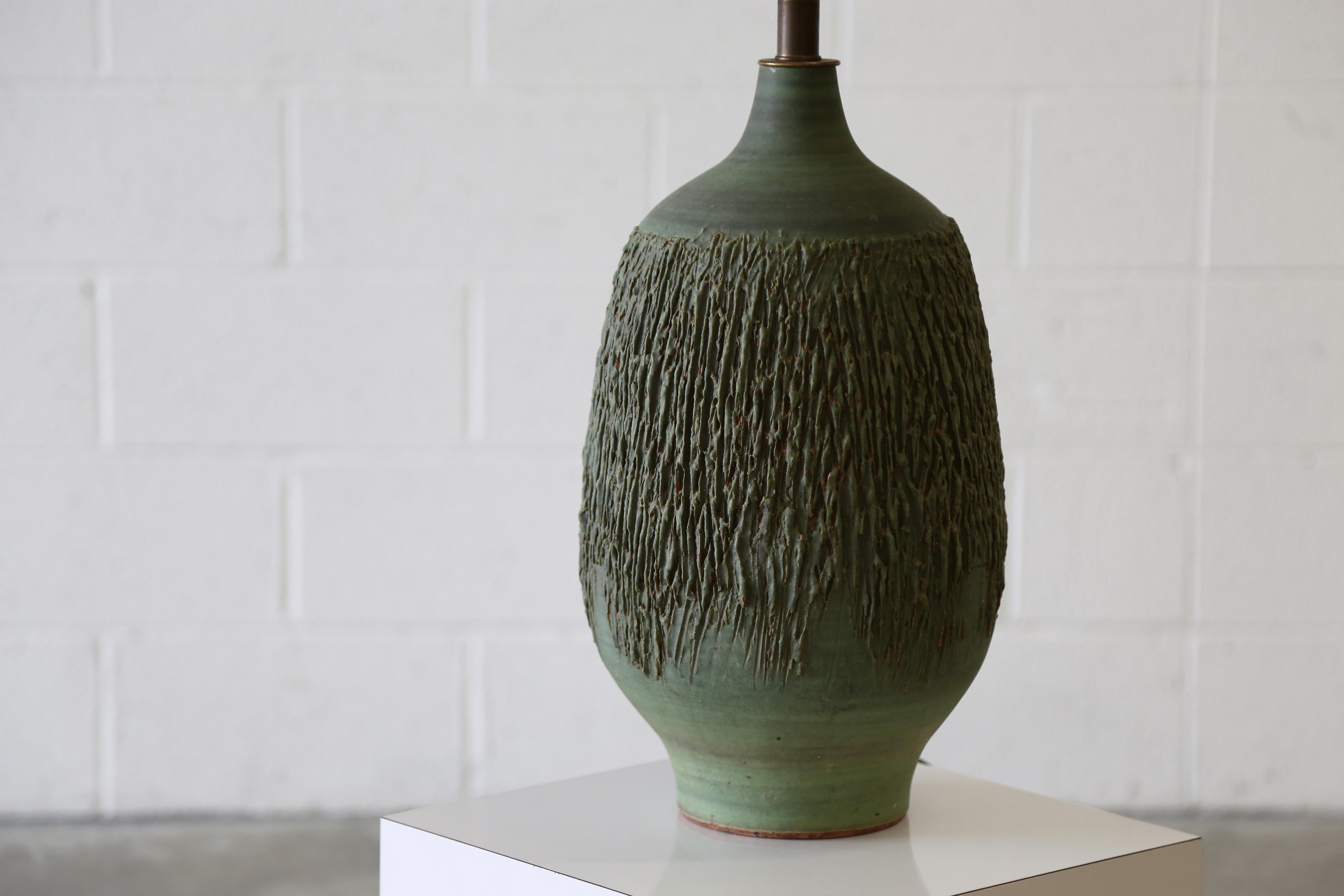 Lámpara de cerámica de los años 60 diseñada por Lee Rosen para Design Technics. Una forma de calabaza con el característico acabado texturizado de Rosen, en un esmalte verde poco común. El esmalte y la textura proyectan sombras que acentúan la