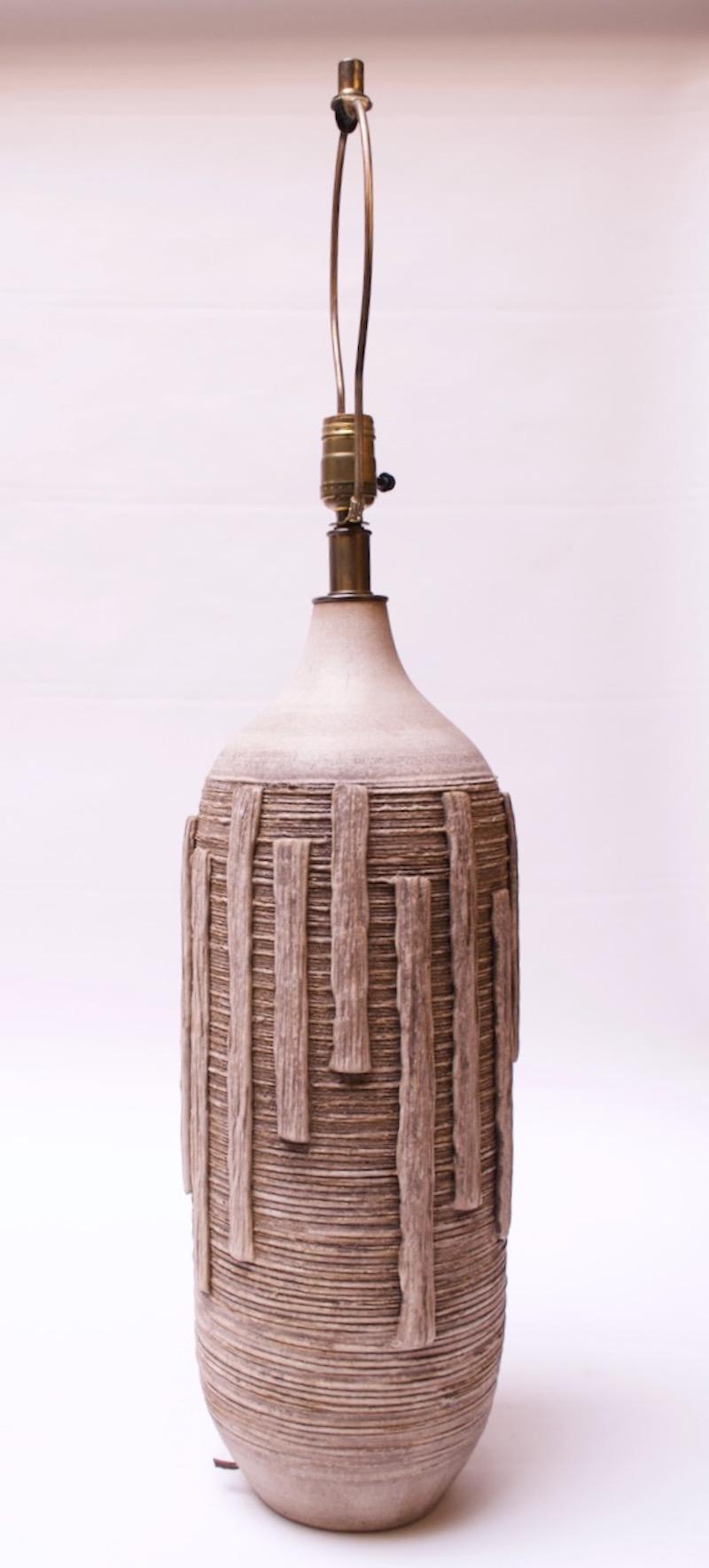 Rare lampe à grande échelle des années 1950, Lee Rosen pour Design Technics, en terre cuite émaillée et tournée à la main, de couleur taupe. Décor horizontal brut et fortement texturé, incisé / sgraffite, avec détails verticaux appliqués en