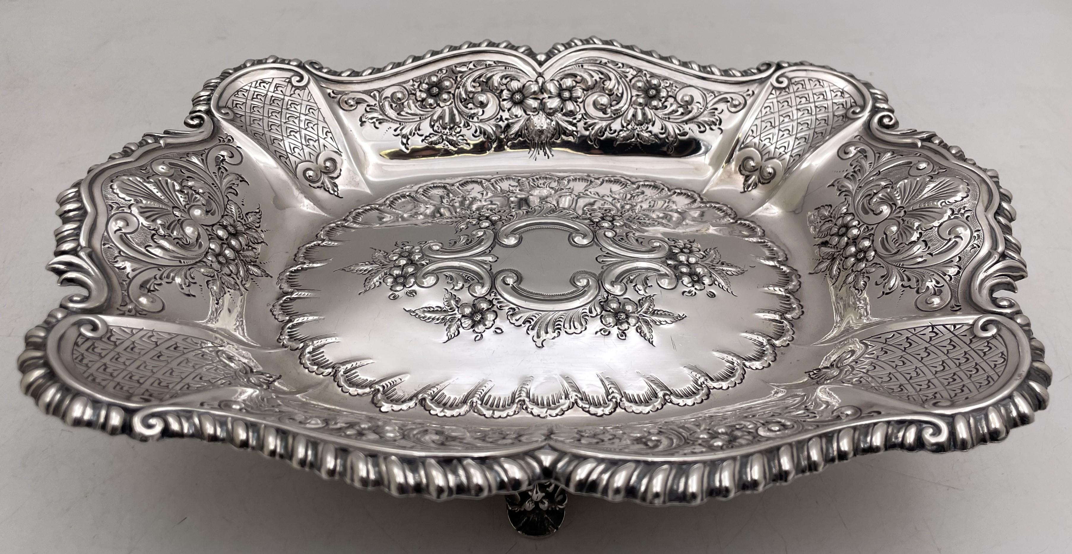 Lee & Wigfull sterling silver bread dish or basket, made in Sheffield, England in 1902 (Edwardian era), beautifully adorned with raised floral and natural motifs, standing on 4 feet. It measures 11 1/8'' in length by 8 3/4'' in width by 2 7/8'' in