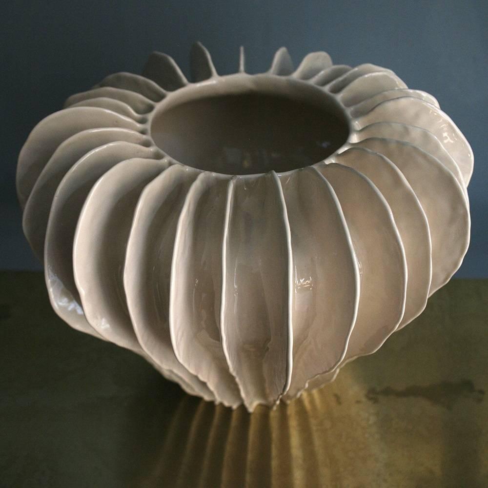 Diese asymmetrische, ziehharmonikaförmige Terrakotta-Vase ist eher ein Kunstobjekt als eine gewöhnliche Vase. Sie ist mit vertikalen, von Hand gefertigten Streifen verziert und wird in zwei Hochtemperatur-Brennvorgängen glasiert. Wie alle Vasen