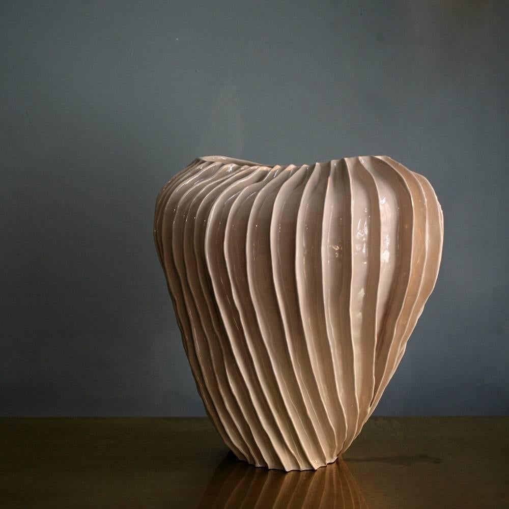 The distinct feature of pieces made with colombino technique is their uniqueness and high aesthetic value. The blush pink glossy glaze obtained during a two-step firing process adds texture to this intriguing vase that features a unique pattern of