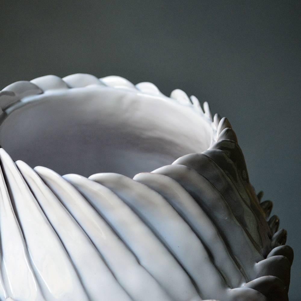 Diese Vase, die nach der Colombino-Methode hergestellt und in einem zweistufigen Brennverfahren glasiert wird, um ihr ein auffallend glänzendes weißes Finish zu verleihen, ist ein echtes Werk höchster Handwerkskunst. Das Dekor besteht aus drei