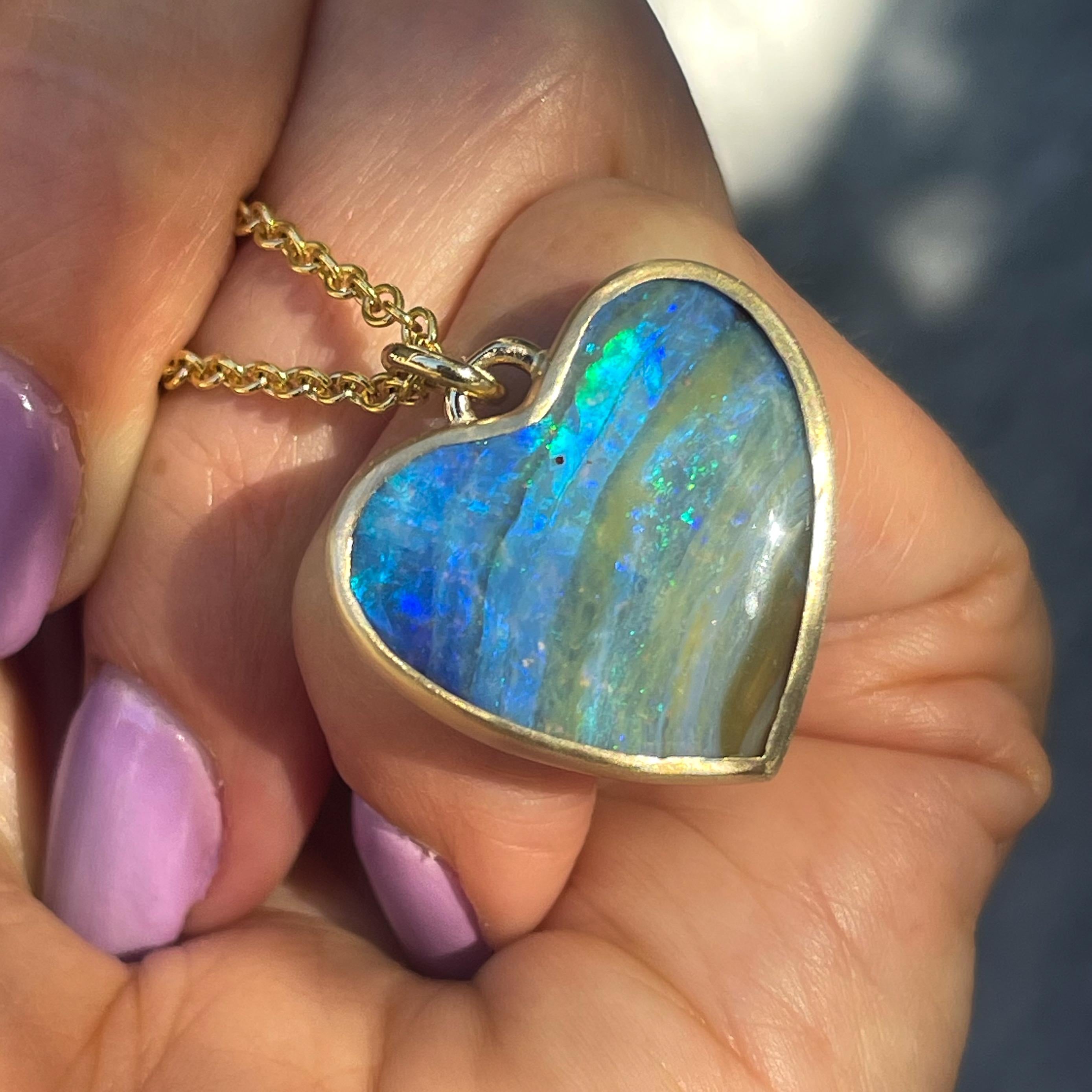A wave of color sweeps across the facade of this Australian Opal Necklace. Within the blue opal heart, the lines are blurred between sea and sky and exactly where they meet the ground. Lively green fire flashes from the opal, and every so often