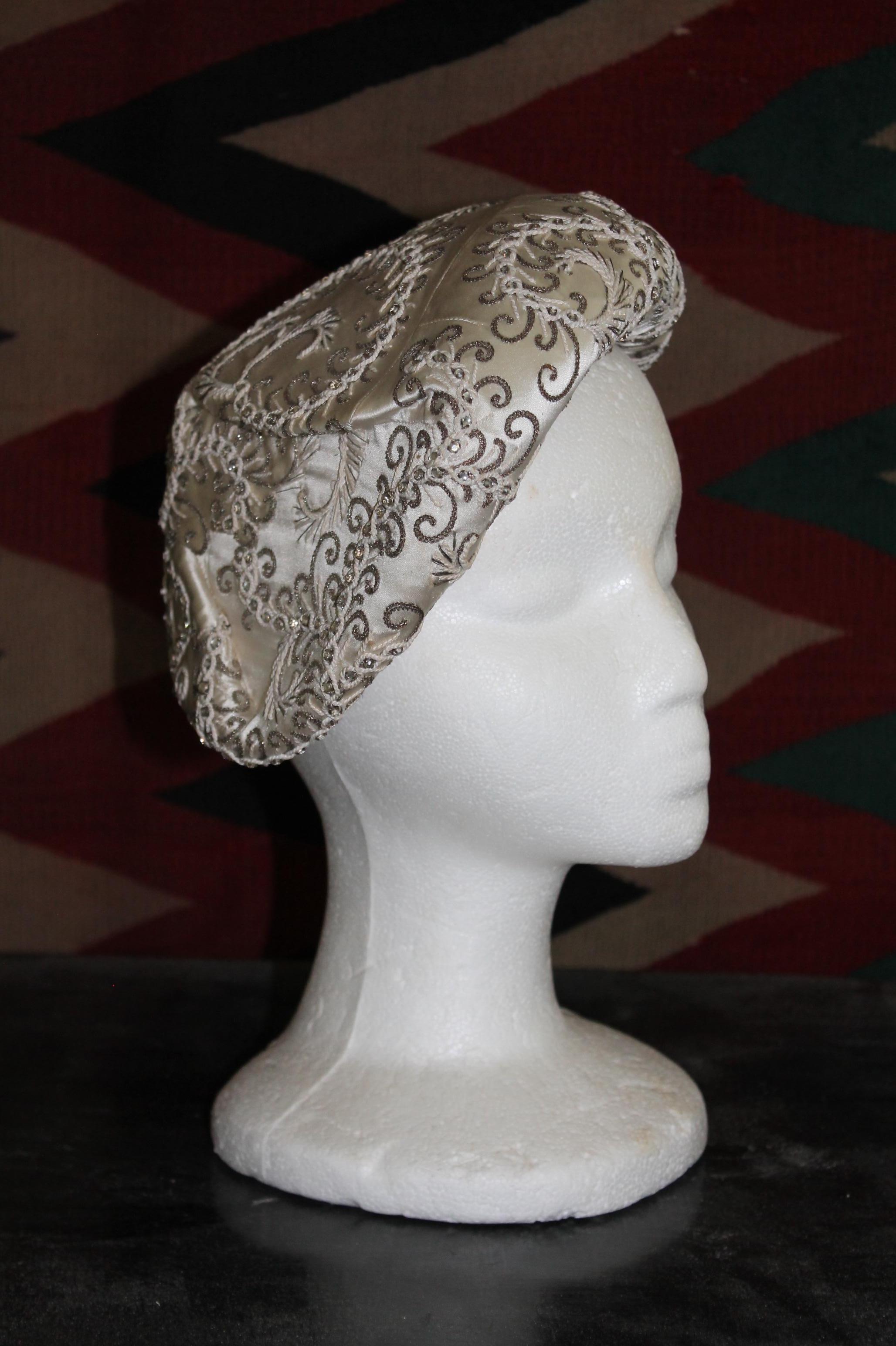 Abstract swirls of crystal and metallic threads, hand sewn and embroidered  on an ivory satin beret style hat.  LeGroux Soeurs, hat makers from the Belle Epoque through the 1950's.  Their salon (est. 1913)
was located across the street from Chanel. 