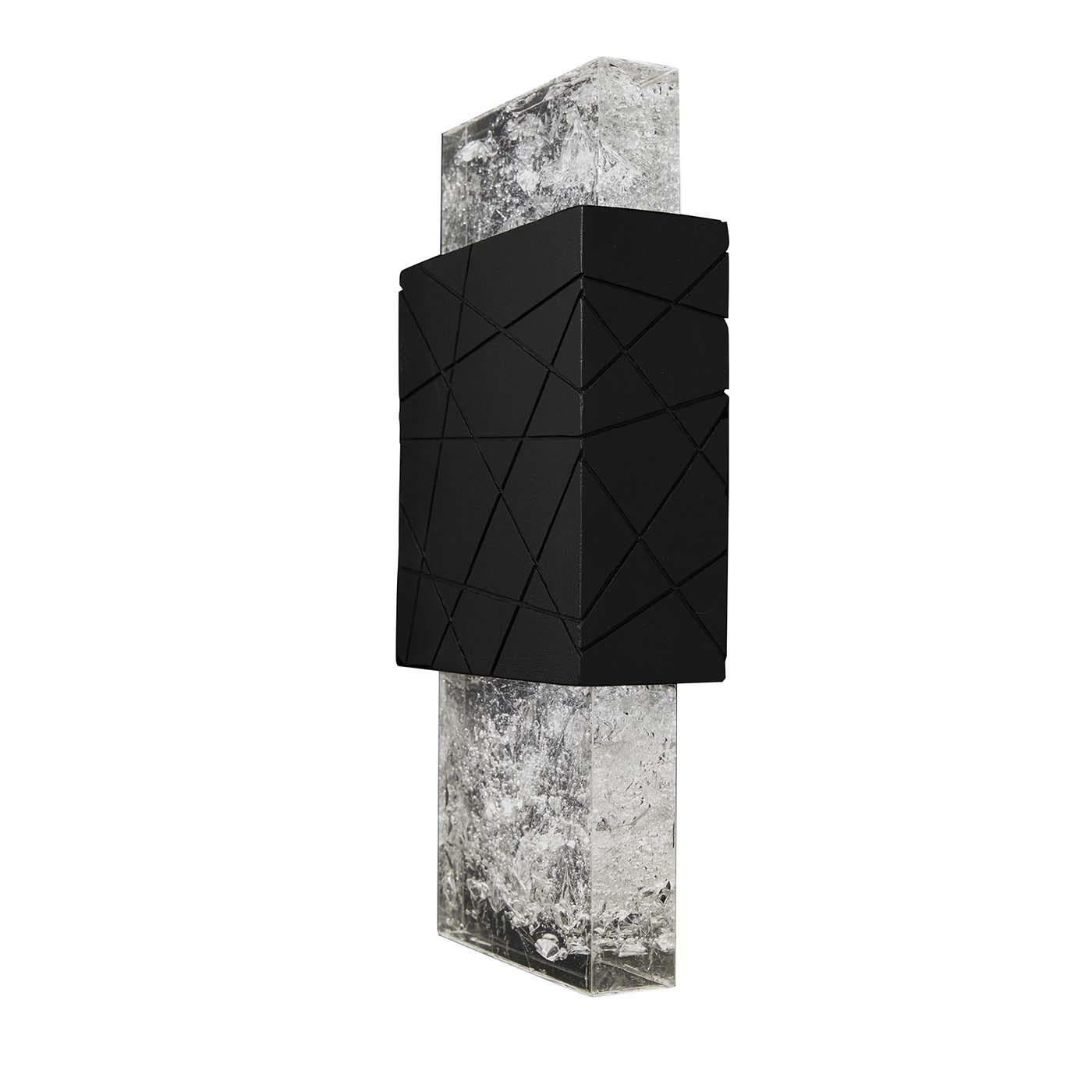 This exquisite wall lamp captures the unique features of the volcanic rock in an essential design suited for modern living interiors. Rich in textures and contrast, the irregular lines engraved on the black porous surface are obtained by applying