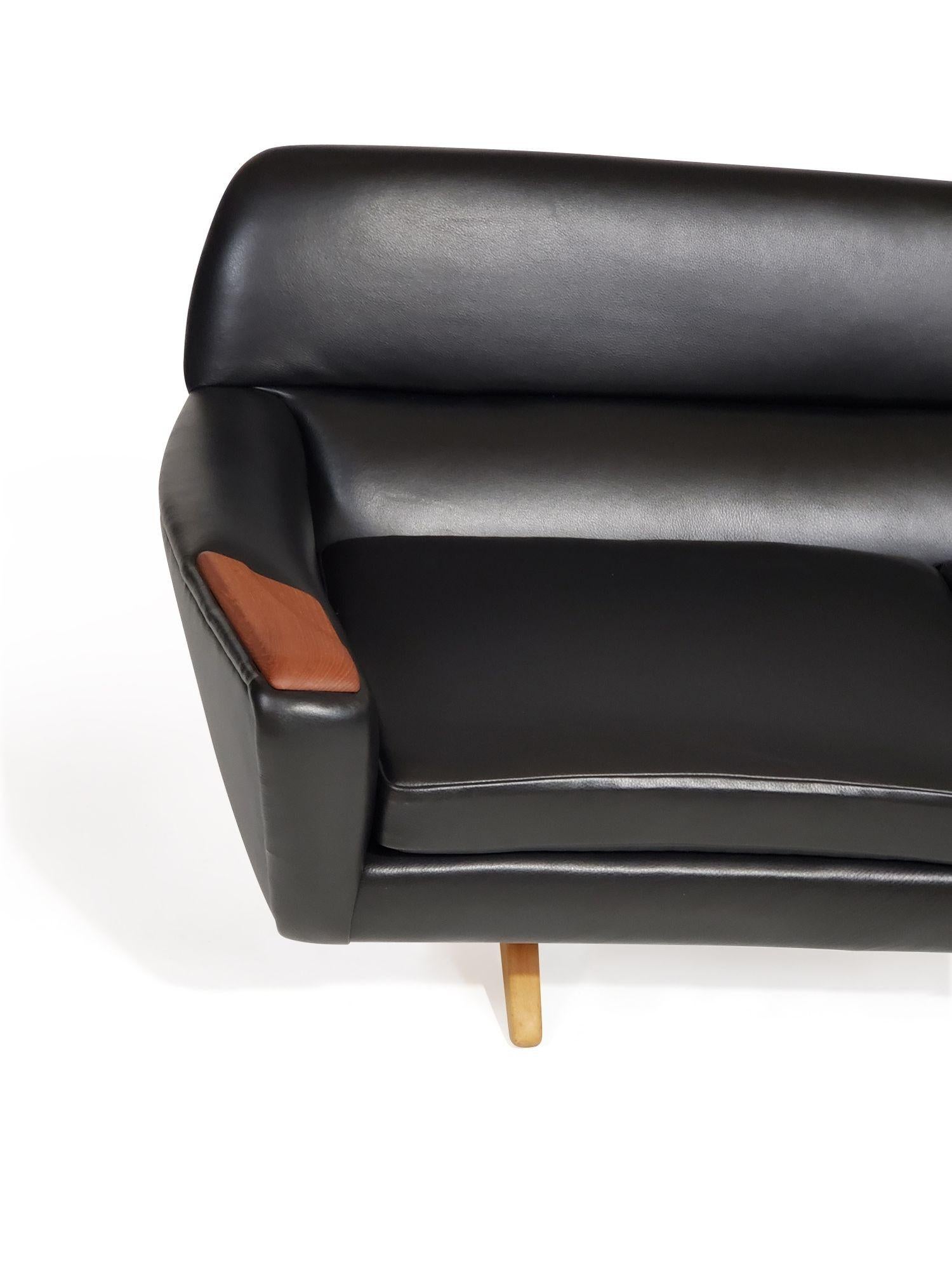 Danish sofa designed by Leif Hansen for Kronen. Crafted of a solid wood frame in a curved form with teak paws, perfectly reupholstered in a full-grain semi-aniline soft black leather. Raised on beech scissor legs. Professionally restored by our team