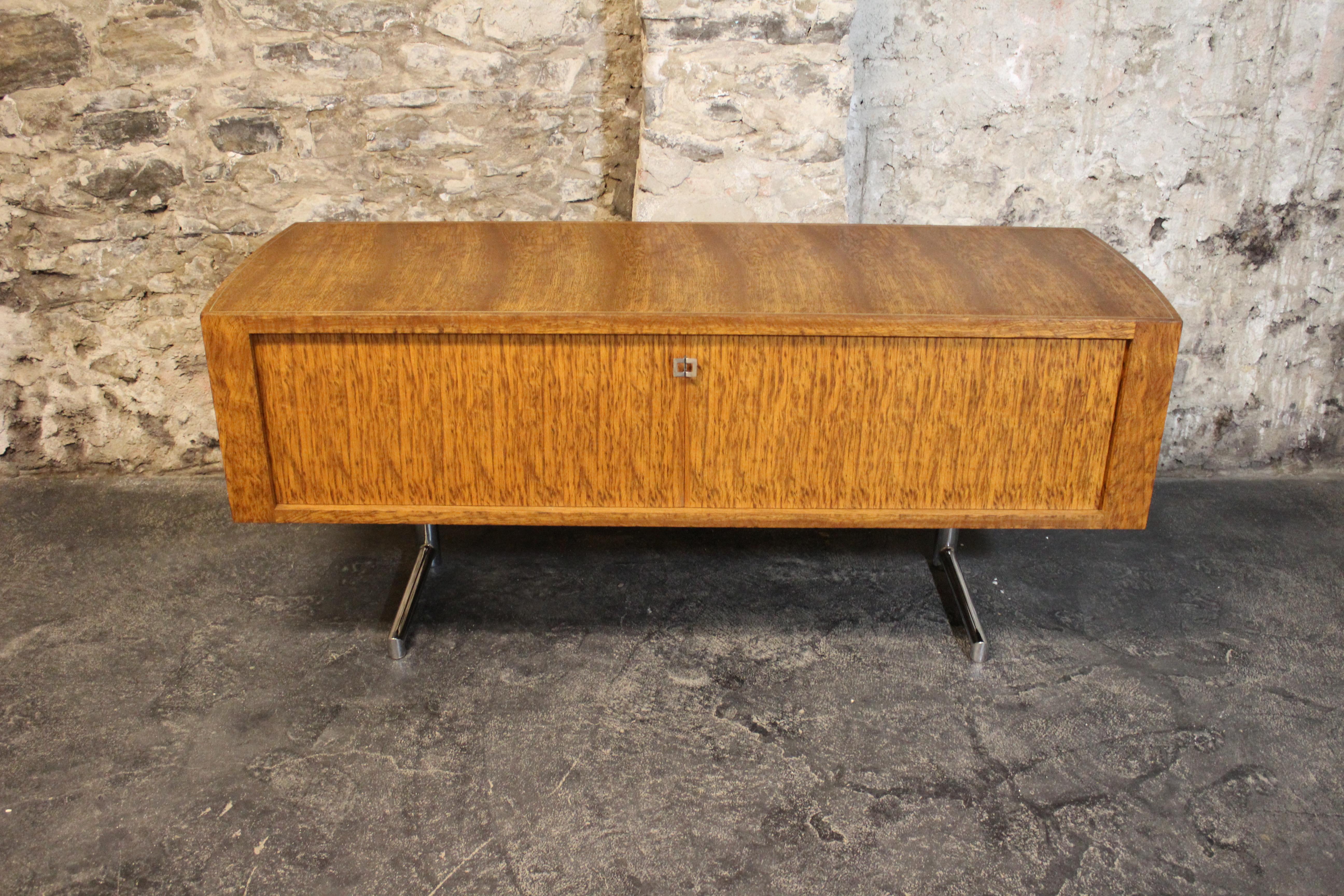 Rare Mid-Century Modern Leif Jacobsen executive credenza, circa 1970. This high quality constructed credenza features beautiful exotic wood grain, tambour doors, a finished back, chrome cantilevered legs, and inset chrome banding on the top. Leif