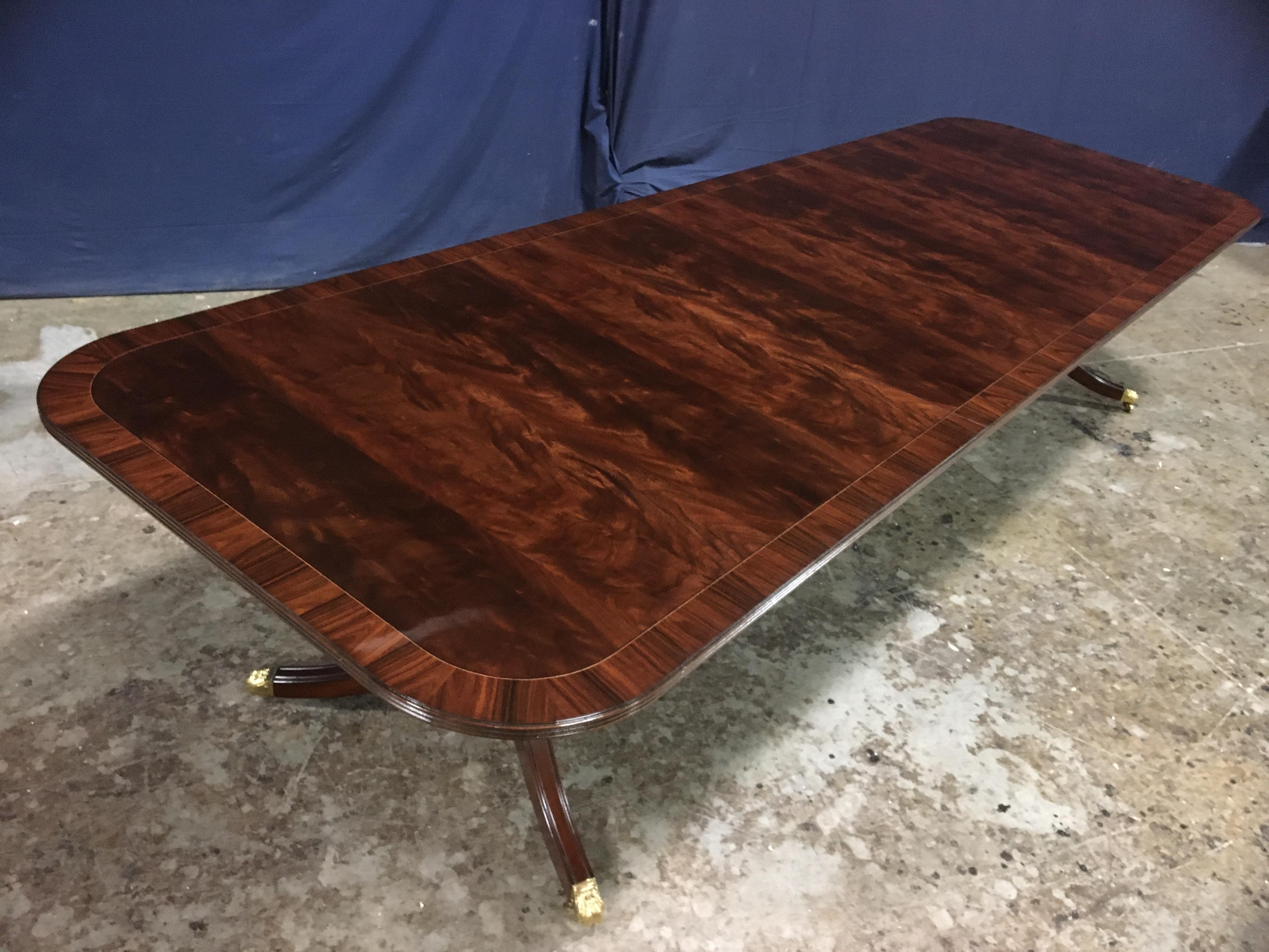 This is a made-to-order traditional mahogany dining table made in the Leighton Hall shop. It features a field of reverse slip-matched swirly crotch mahogany from west Africa and a Santos rosewood border from South America. It has a hand rubbed and