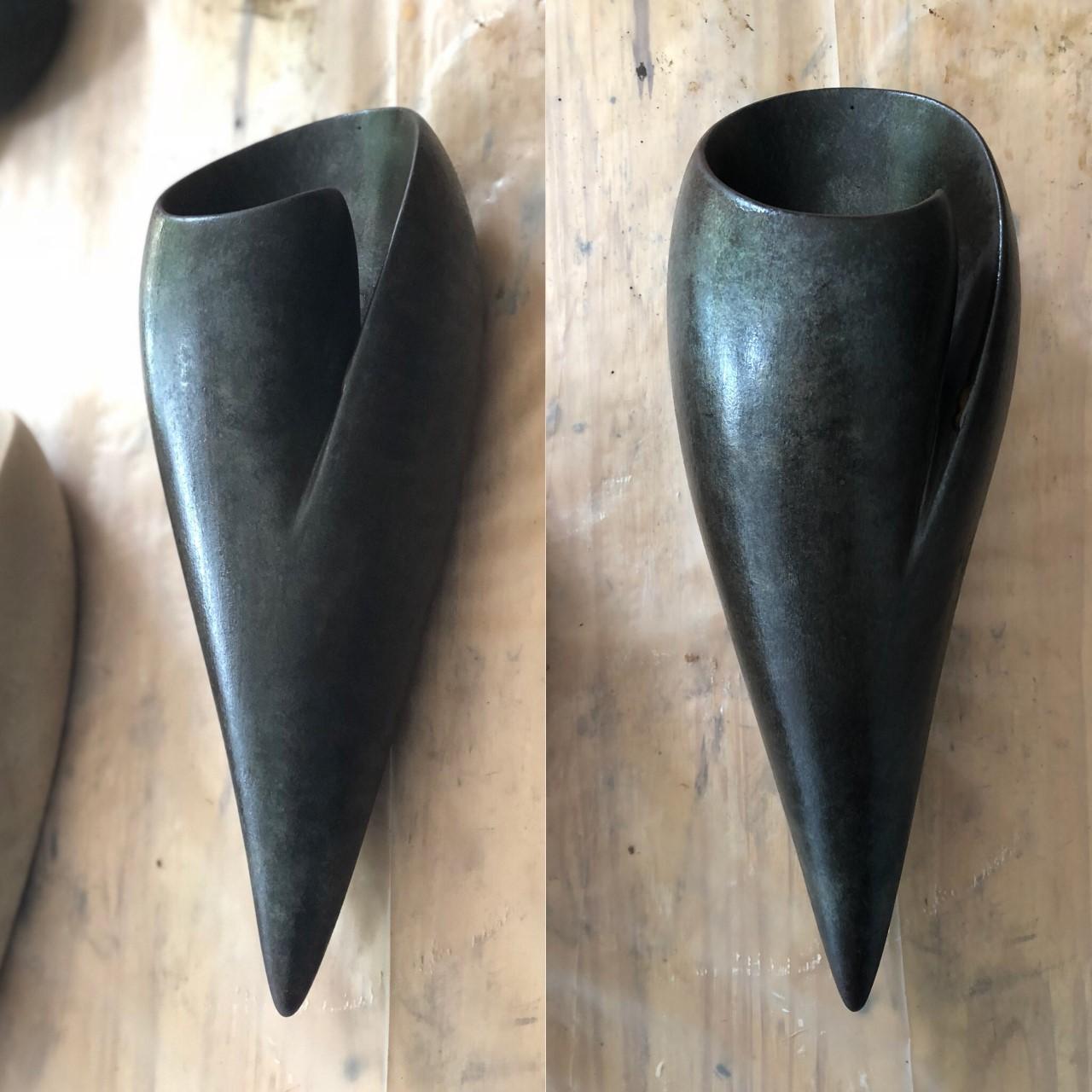 Handmade Leila plaster wall light or sconce, in silky smooth ebony finish, created by artist Hannah Woodhouse in her London studio. Contemporary design inspired by nature and mid-century European sculpture. The Leila wall sconce not only provides