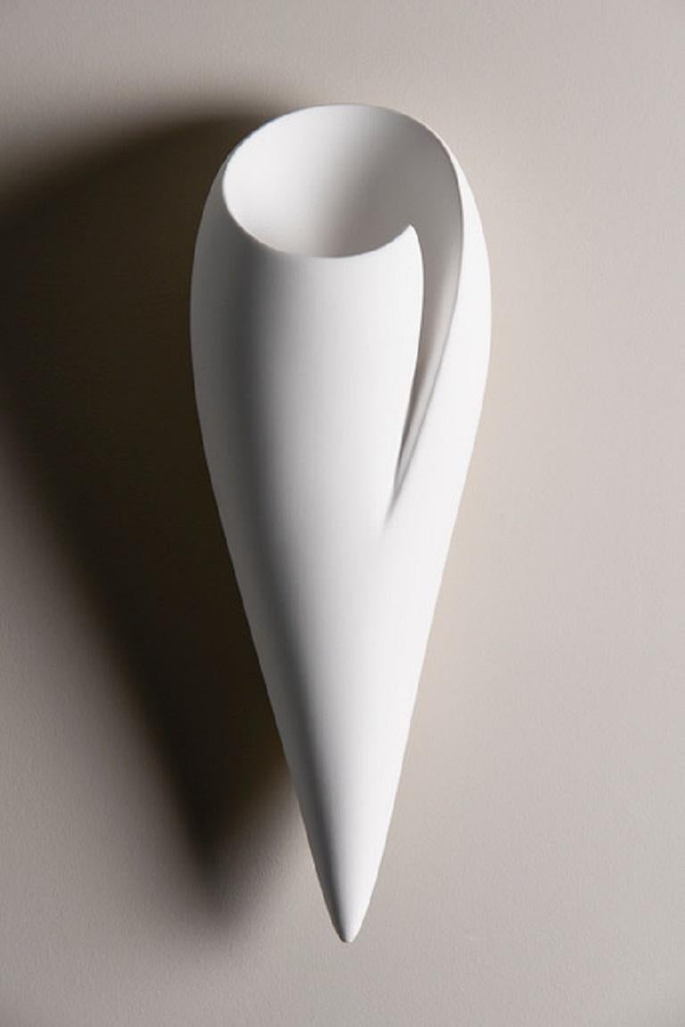 Handmade Leila wall light or sconce, in silky smooth white plaster, created by artist Hannah Woodhouse in her London studio. Contemporary design inspired by nature and mid-century European sculpture. The Leila wall sconce not only provides soft