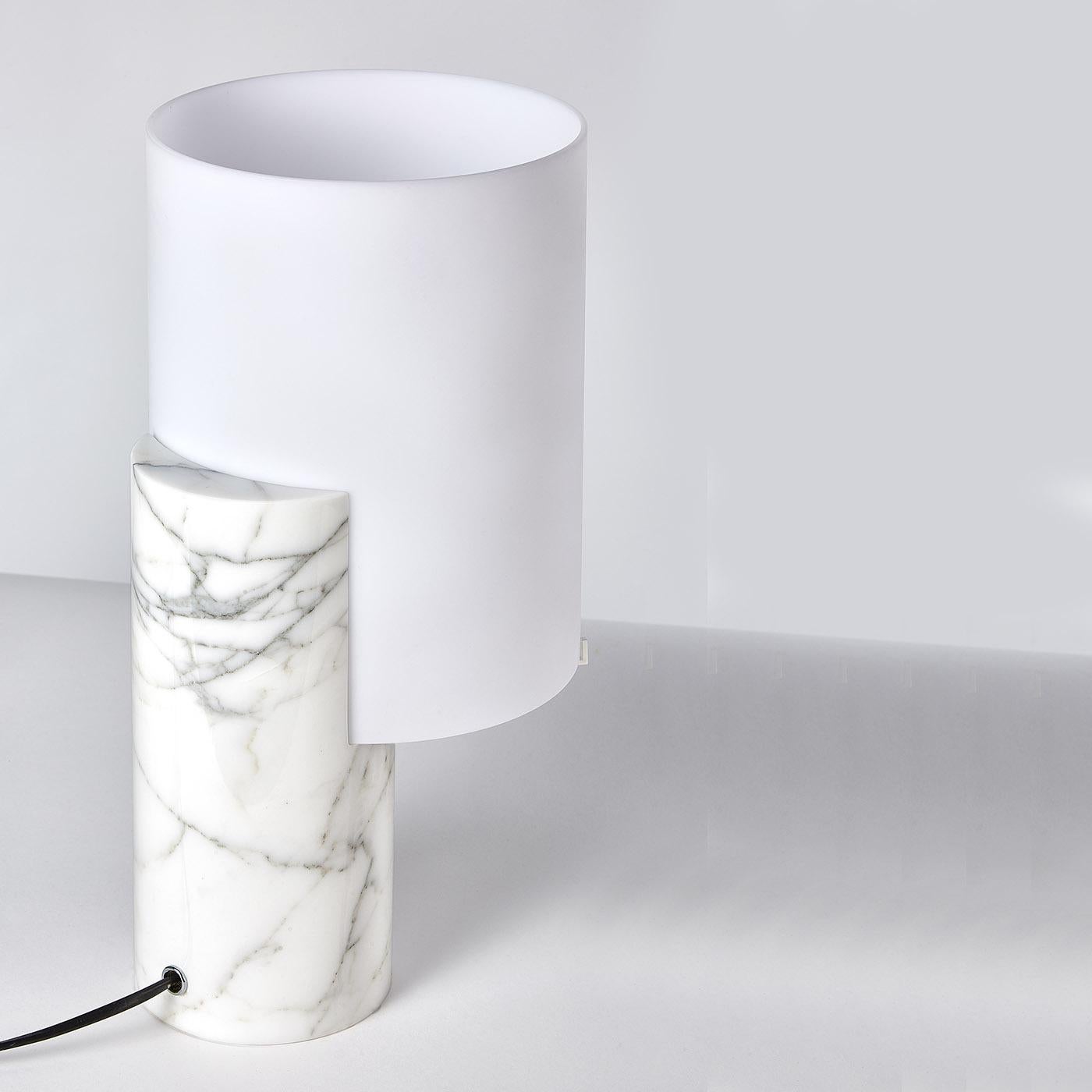 A testament to elegance and simplicity, this stupendous table lamp is minutely handcrafted of first-rate materials and rendered in clean and pure forms. Mounted on a white Carrara marble body, the satin white shade is made of polycarbonate. Designed