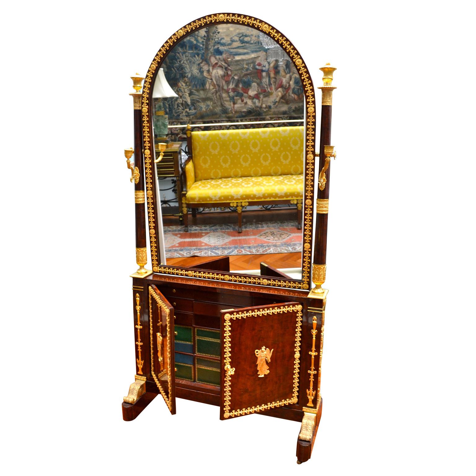 Ein Spiegel- und Schmuckschrank aus Mahagoni, der einst Leitizia Bonaparte, der Mutter von Napoleon, gehörte. Der furnierte, halbrunde Spiegel wird von Säulen umrahmt, die mit vergoldeten Bronzekassetten und einarmigen Kerzenhaltern versehen