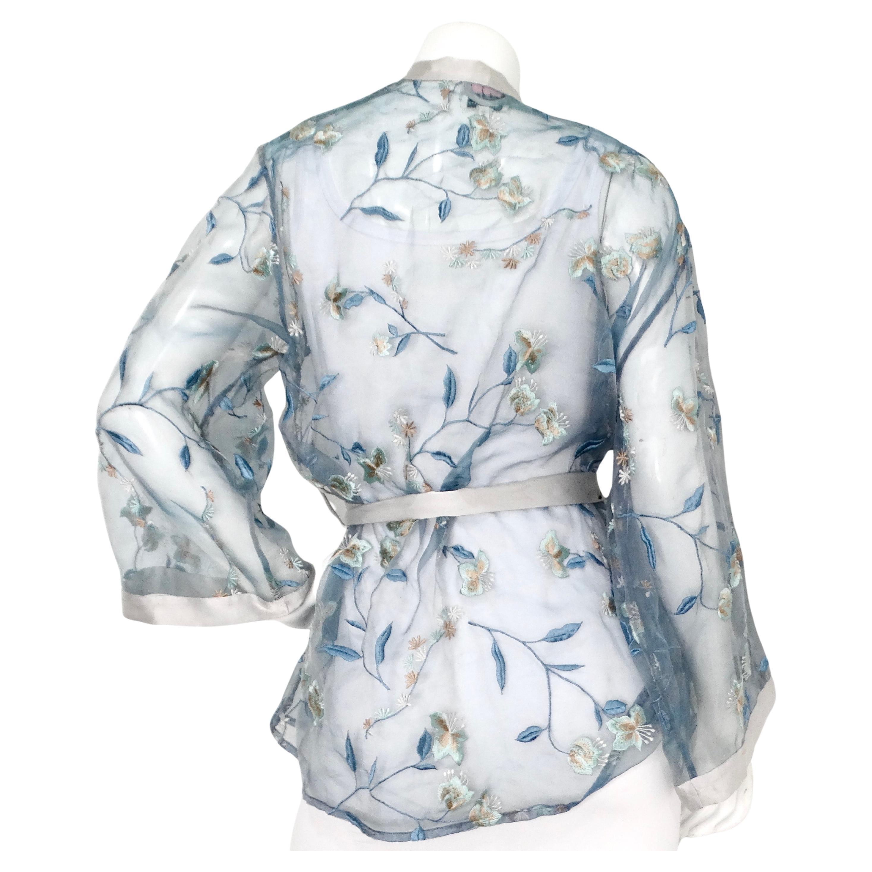 Der Lejaby Paris for Saks Sheer Blue Floral Embroidered Kimono aus den CIRCA 1980er Jahren ist ein atemberaubendes Beispiel für Vintage-Luxus und aufwendige Handwerkskunst. Dieser Kimono aus zartem, hauchdünnem Stoff ist mit wunderschönen blauen