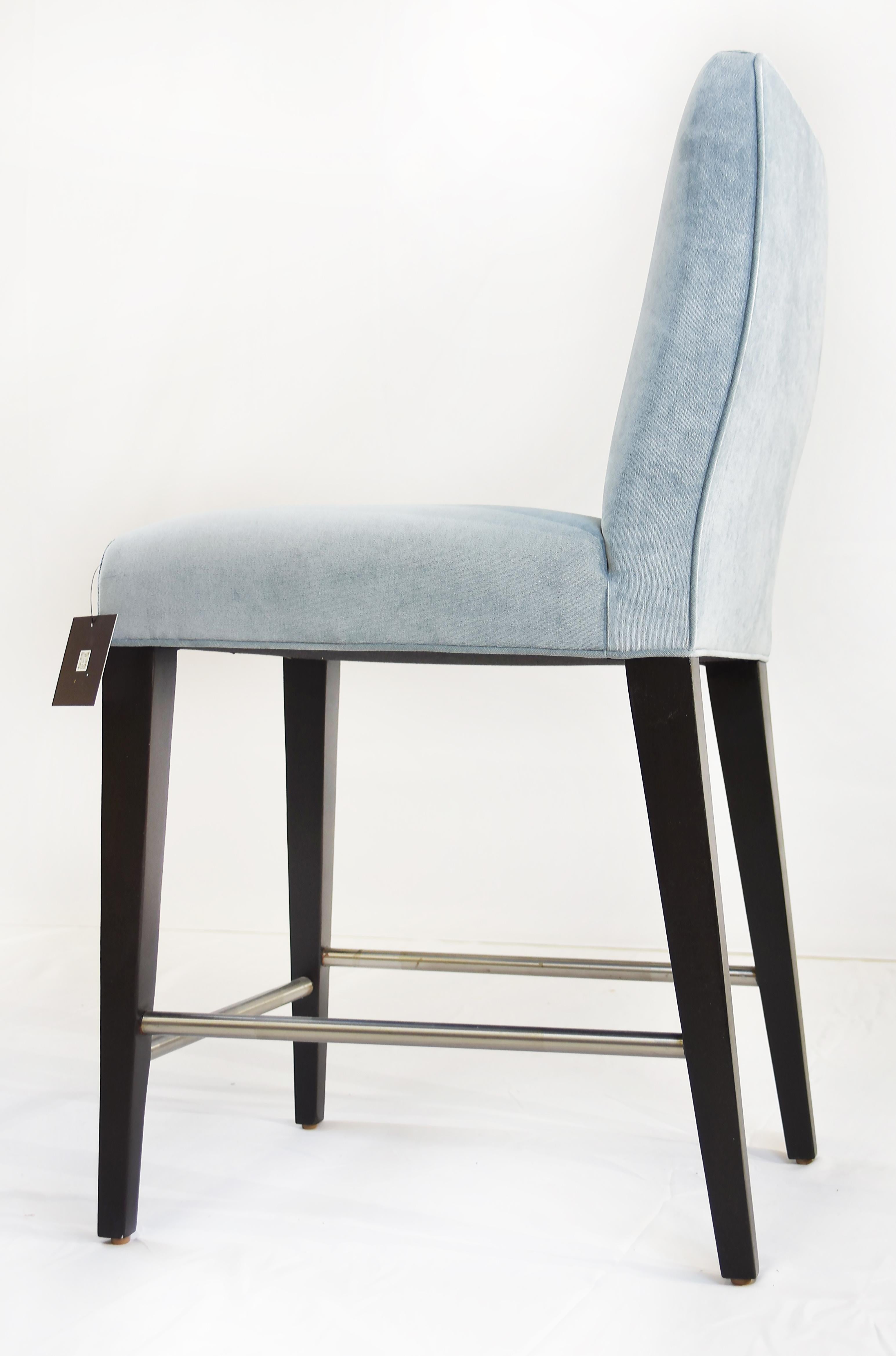 Le Jeune Upholstery Cutler Counter Stool Floor Model with Metal Footrest

Offered for sale is a counter-height Cutler bar stool showroom floor sample from Le Jeune Upholstery. The stool has a tight seat and back with exposed Mahogany wood legs done