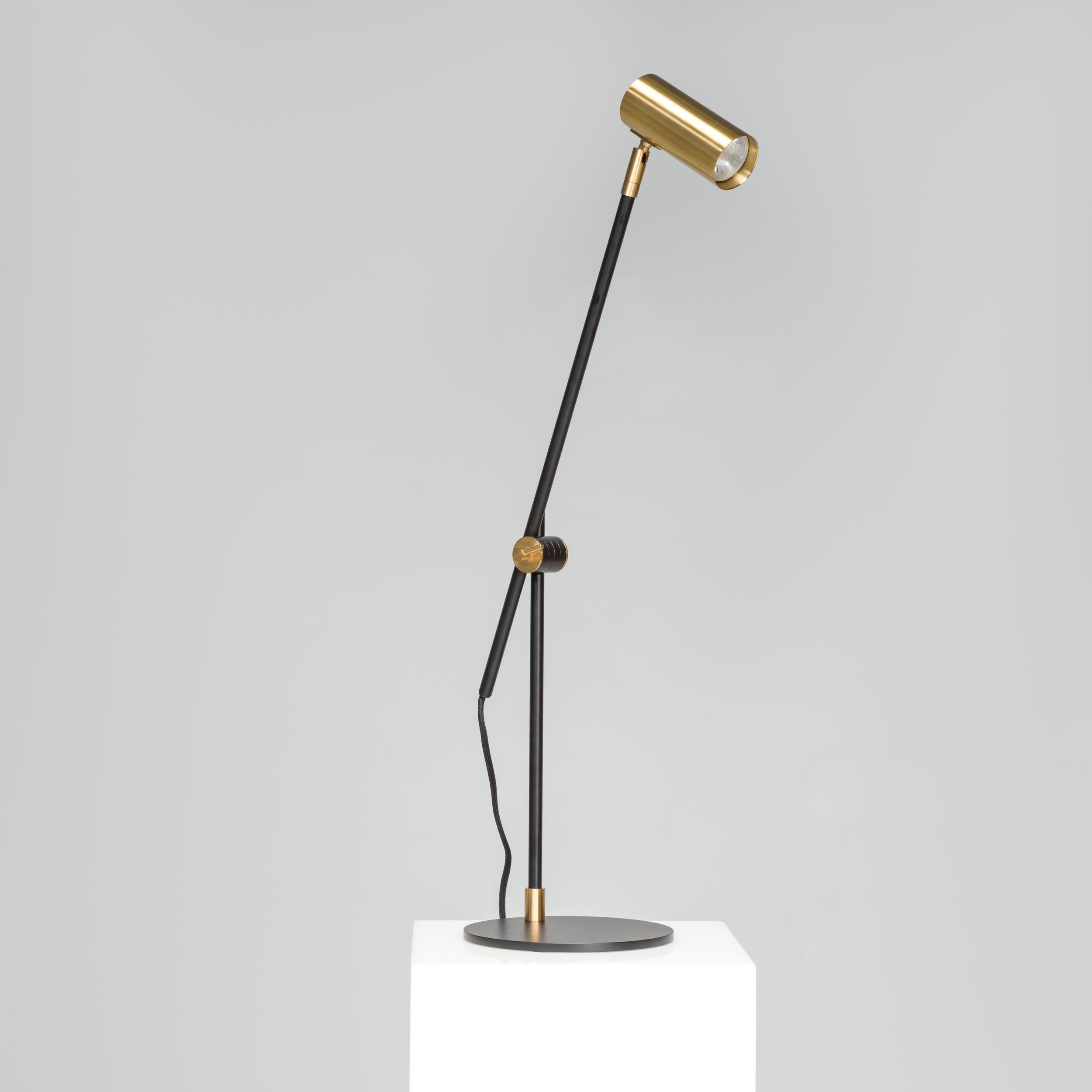 Designée par Niclas Hoflin, la lampe de bureau Lektor est dotée d'un socle en fer plat et circulaire qui offre une forme pratique et contrastante par rapport au reste du design de la lampe. La structure épurée et élégante est construite en laiton