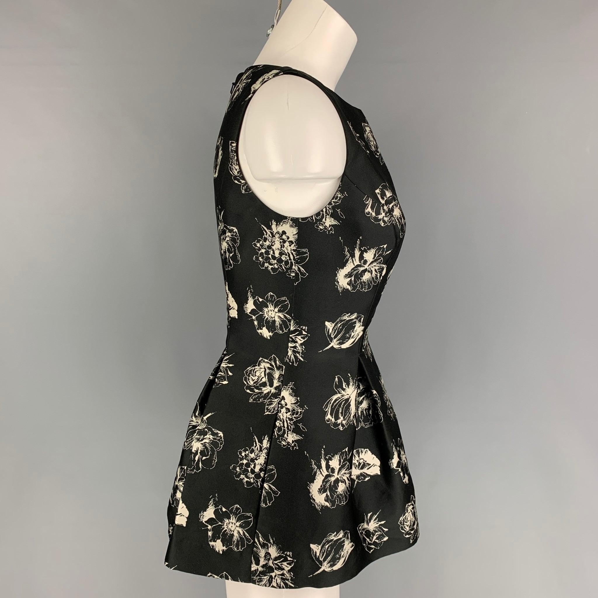 LELA ROSE blouse comes in a black & whit satin floral material featuring a peplum style, sleeveless, and a back zip up closure.
Very Good
Pre-Owned Condition. Fabric tag removed.  

Marked:   Size tag removed.  

Measurements: 
 
Shoulder: 13 inches