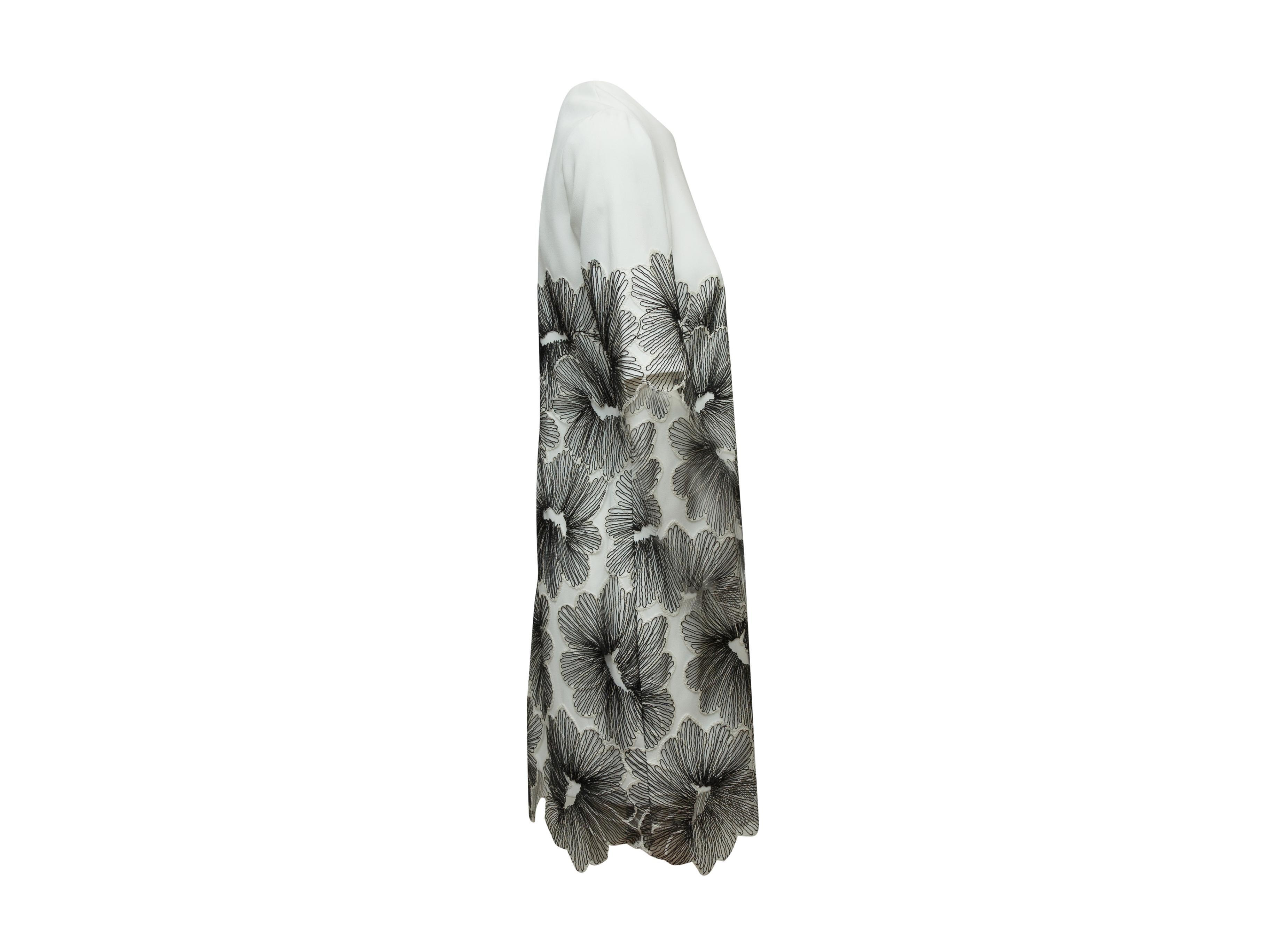 Product details: White short sleeve dress by Lela Rose. Black floral patterned overlay. Zip closure at back. 36