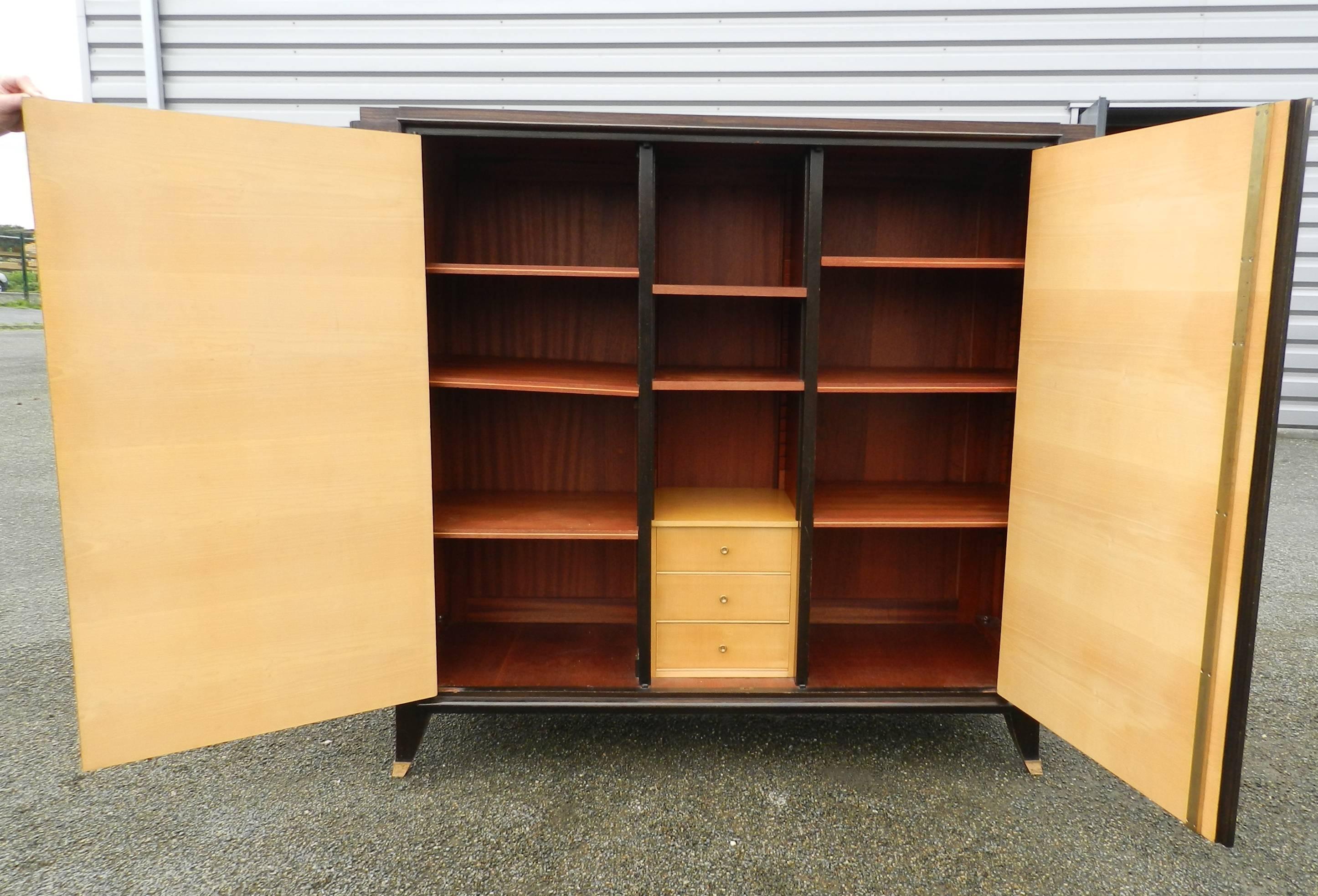 Art Deco low rosewood and gilt brass armoire.
Opening with two doors. Feet in gilt brass,
1930.