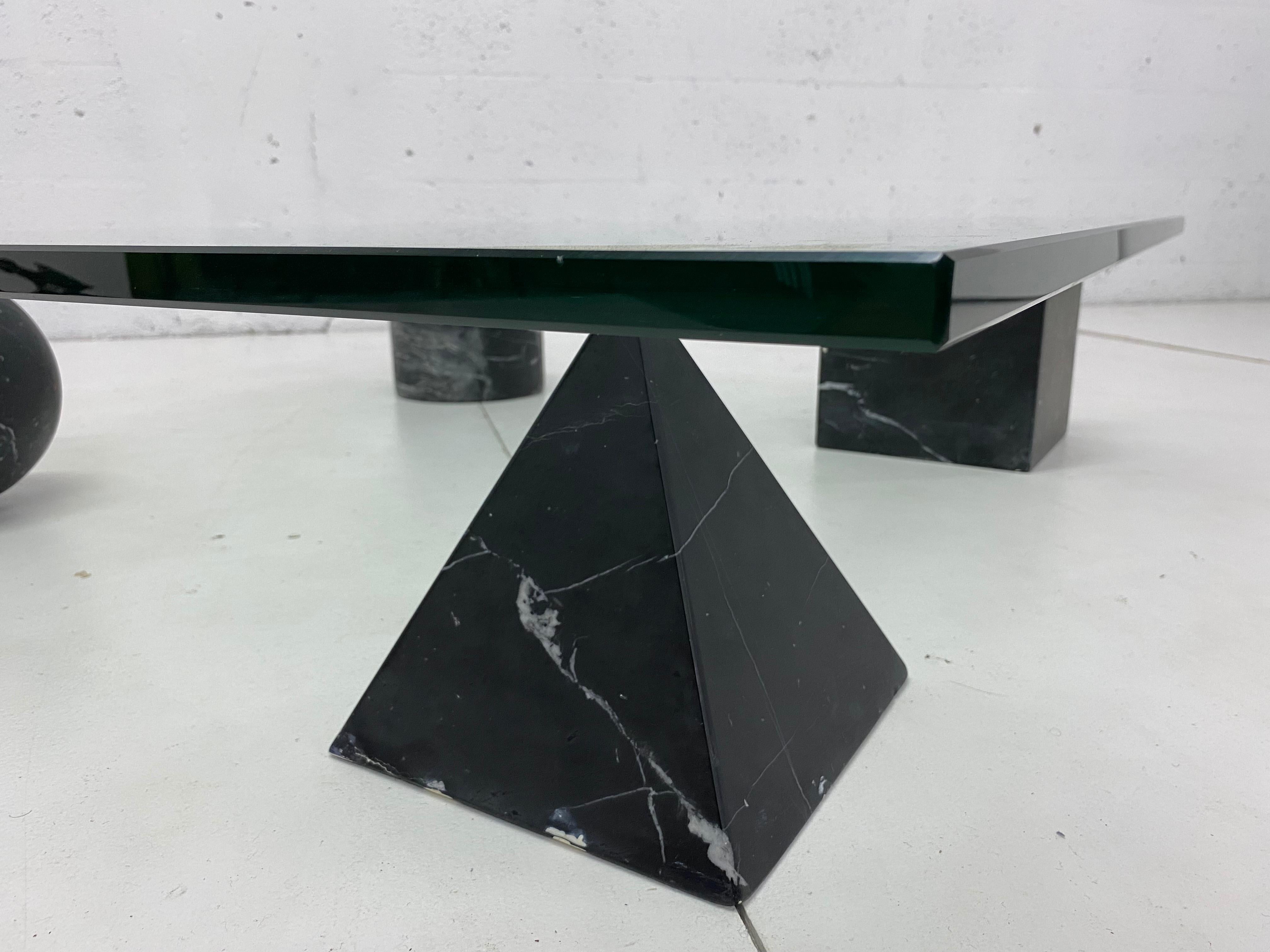 Metafora glass and matte black marble coffee table by Massimo and Lella Vignelli produced by Casigliani, Italy, circa 1979. Table consists of four different shaped marble legs that support a 3/4