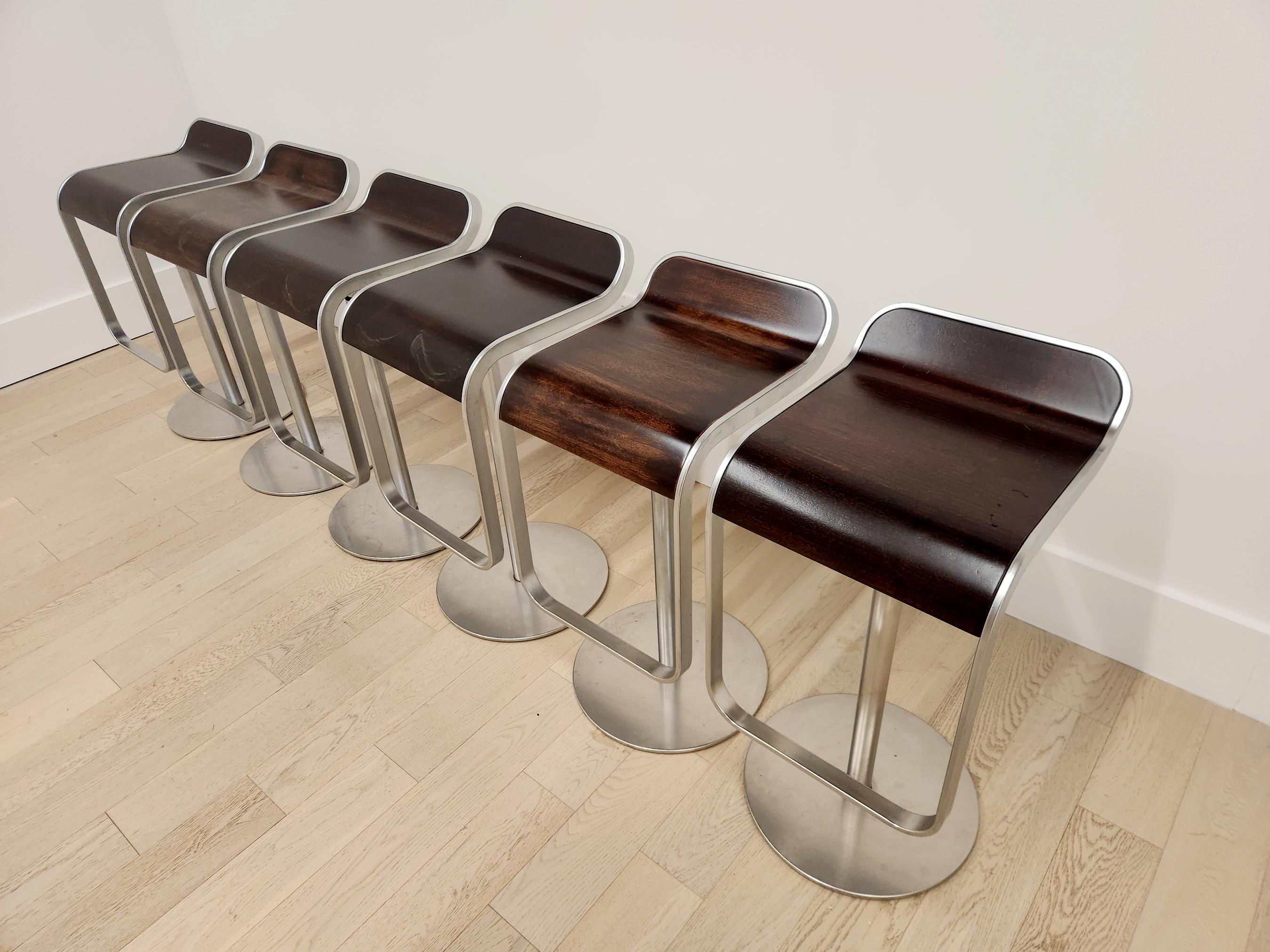 The LEM Piston bar stools were designed by Shin and Tomoko Azumi and made in Italy by LaPalma.   The logo is etched on the bottom of the stool.  Ergonomically designed stainless steel curved frame with beautiful dark oak seat.   The height