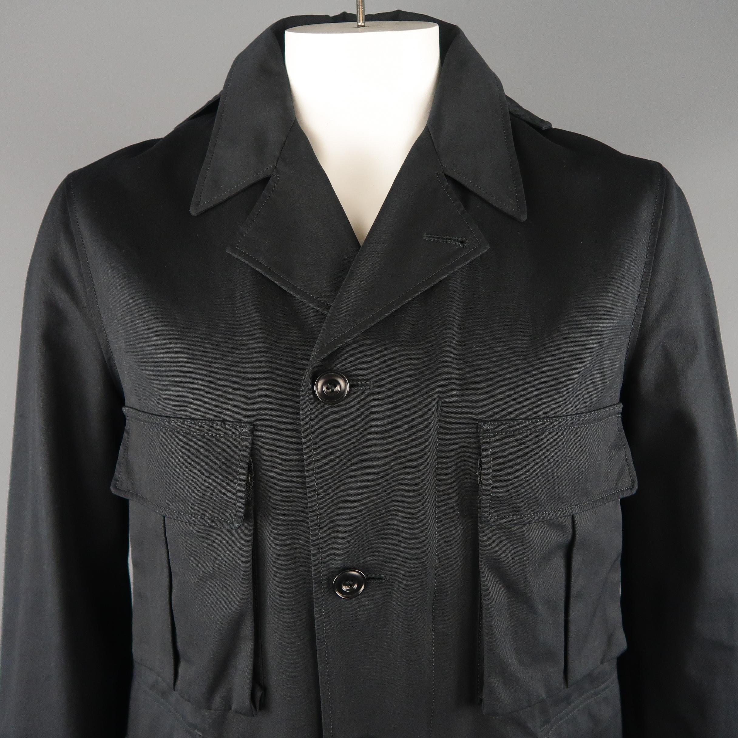 LEMAIRE coat comes in a navy tone in a solid cotton material lined with wool, with a ball collar, detachable hood, cargo and flap pockets, buttoned. Made in Romania.
 
Excellent Pre-Owned Condition.
Marked: 48
 
Measurements:
 
Shoulder: 18.5