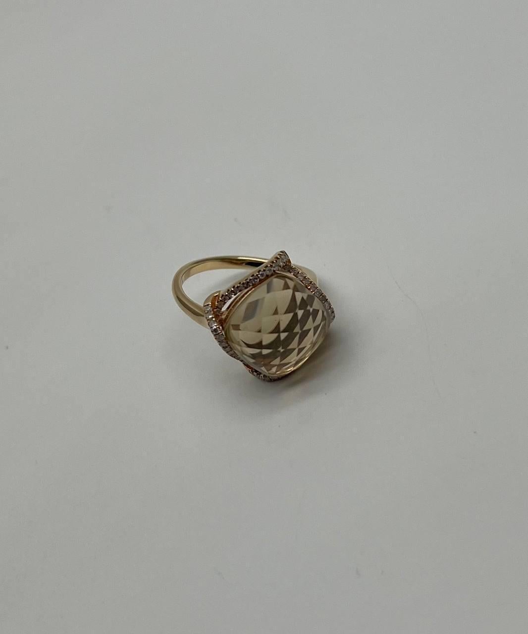 Questo elegante anello presenta un grande quarzo giallo limone sfaccettato e tagliato a cuscino, incastonato in una fascia elegante. La gemma è incorniciata da una delicata aureola di diamanti scintillanti, che ne esaltano la brillantezza.