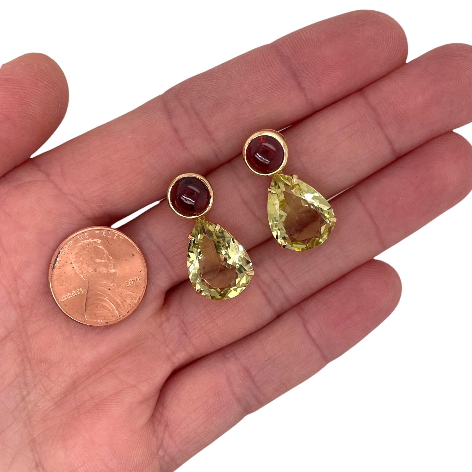 Les boucles d'oreilles contiennent 2 quartz citron en forme de poire, 12x15mm et 2 grenats cabochons ronds, 7mm pesant un total d'environ 7.50cts Les pierres sont montées en or jaune 18k en serti clos et en chaton pesant un total de 6.43grammes. Les