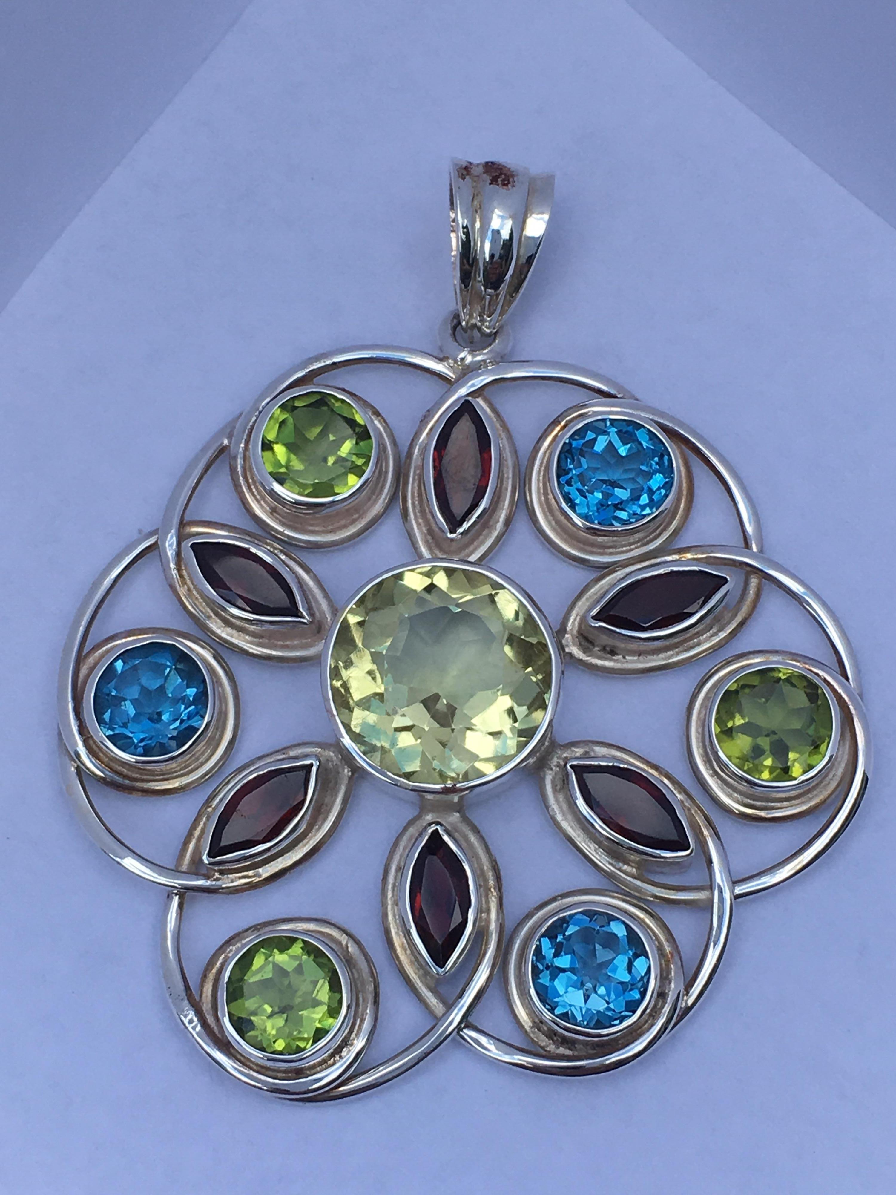 Round 13 MM Hand cut and polished Lemon Quartz , 7 MM Blue topaz and 7 MM Peridot with Marquise 
4 MM X 8 MM Garnet.
Pendant Measures about 50 MM Round.
Total Weight of Pendant is 20.35 Gram
You can wear on Silver chain or Leather band .