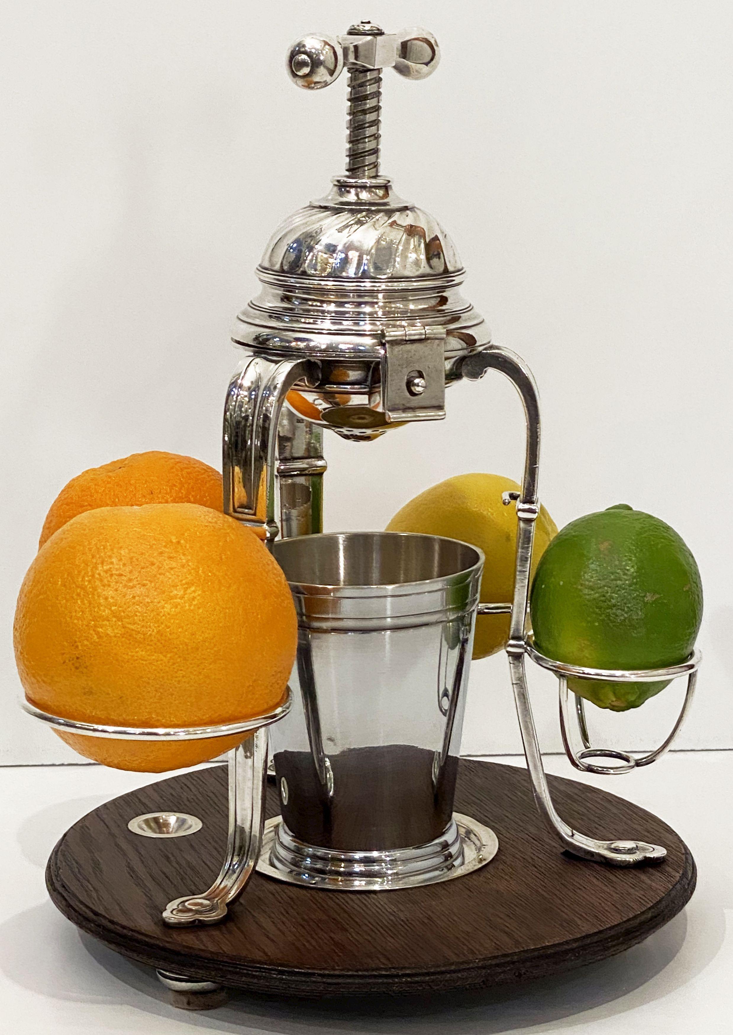 A fine lemon squeeze or citrus juicer from Corsica, featuring a plate silver apparatus with handle and squeeze mounted to a wood base, with a removable tumbler or container for the collected juice.
