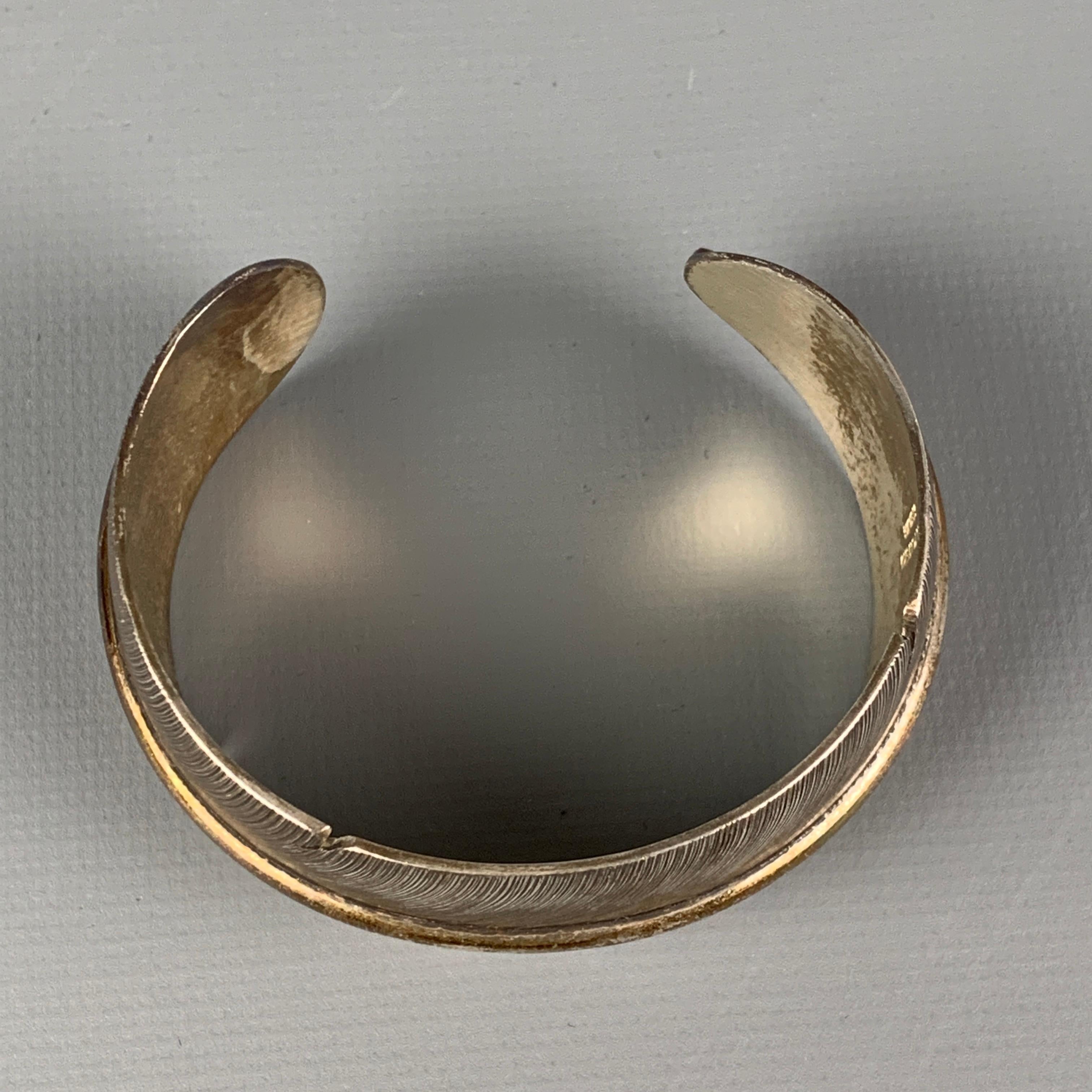 LENA PLATERO bracelet comes in a sterling silver featuring a navajo feather design and a cuff style. 

Good Pre-Owned Condition.

Measurements:

Fits: 2.25 in. 
