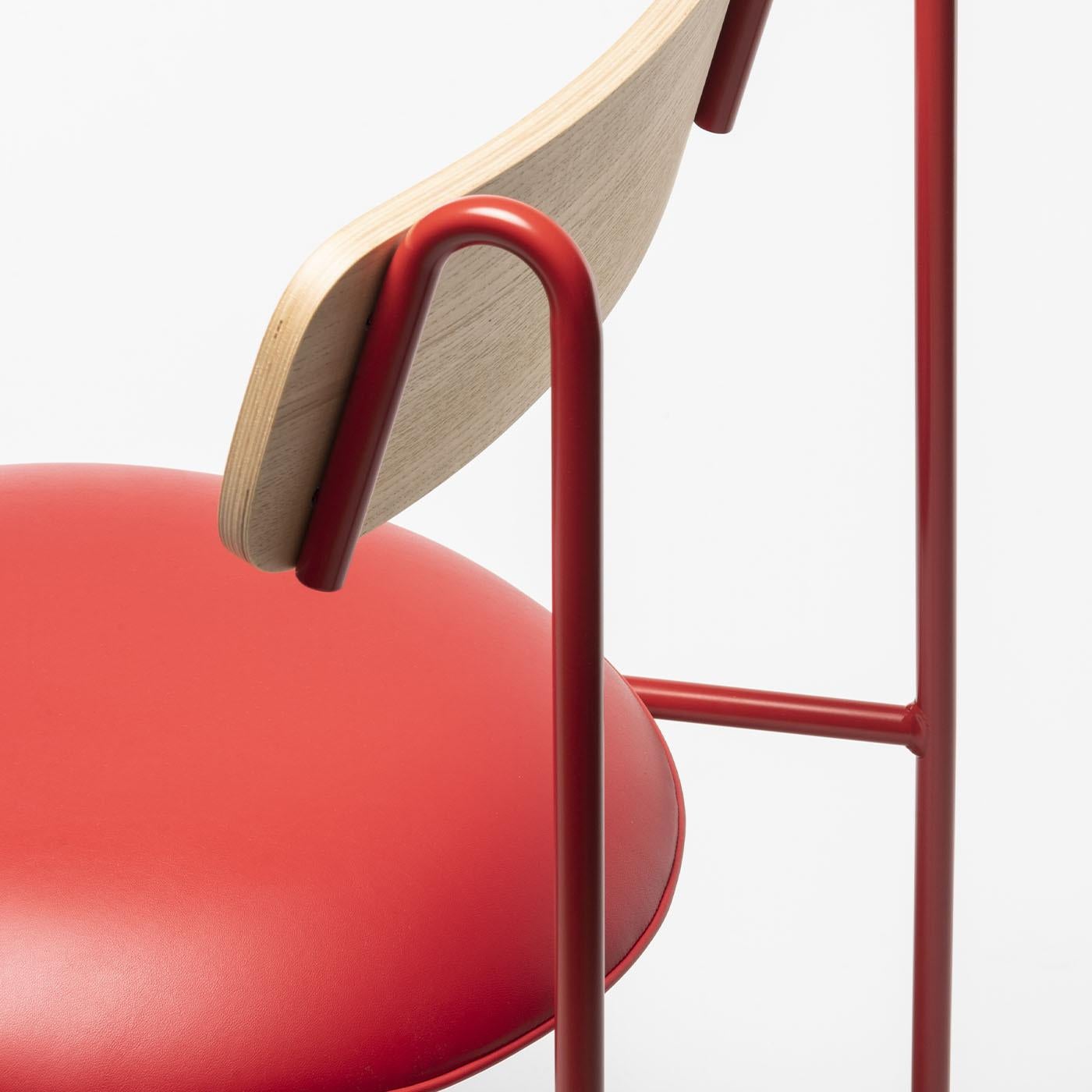 Red powder-coated metal frame with natural polished ash veneered backrest and an upholstered seat in red eco-leather. The Lena beautifully merges playful minimalism with graphic design influence, creating a captivating harmony between style and