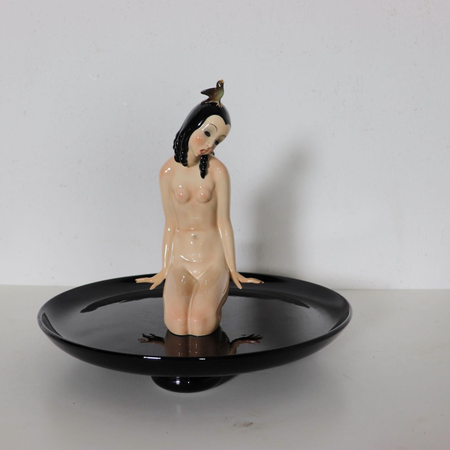 Naked woman with bird on a plate; painted Majolica earthenware sculpture. Manufacturing brand and tag under the base,.