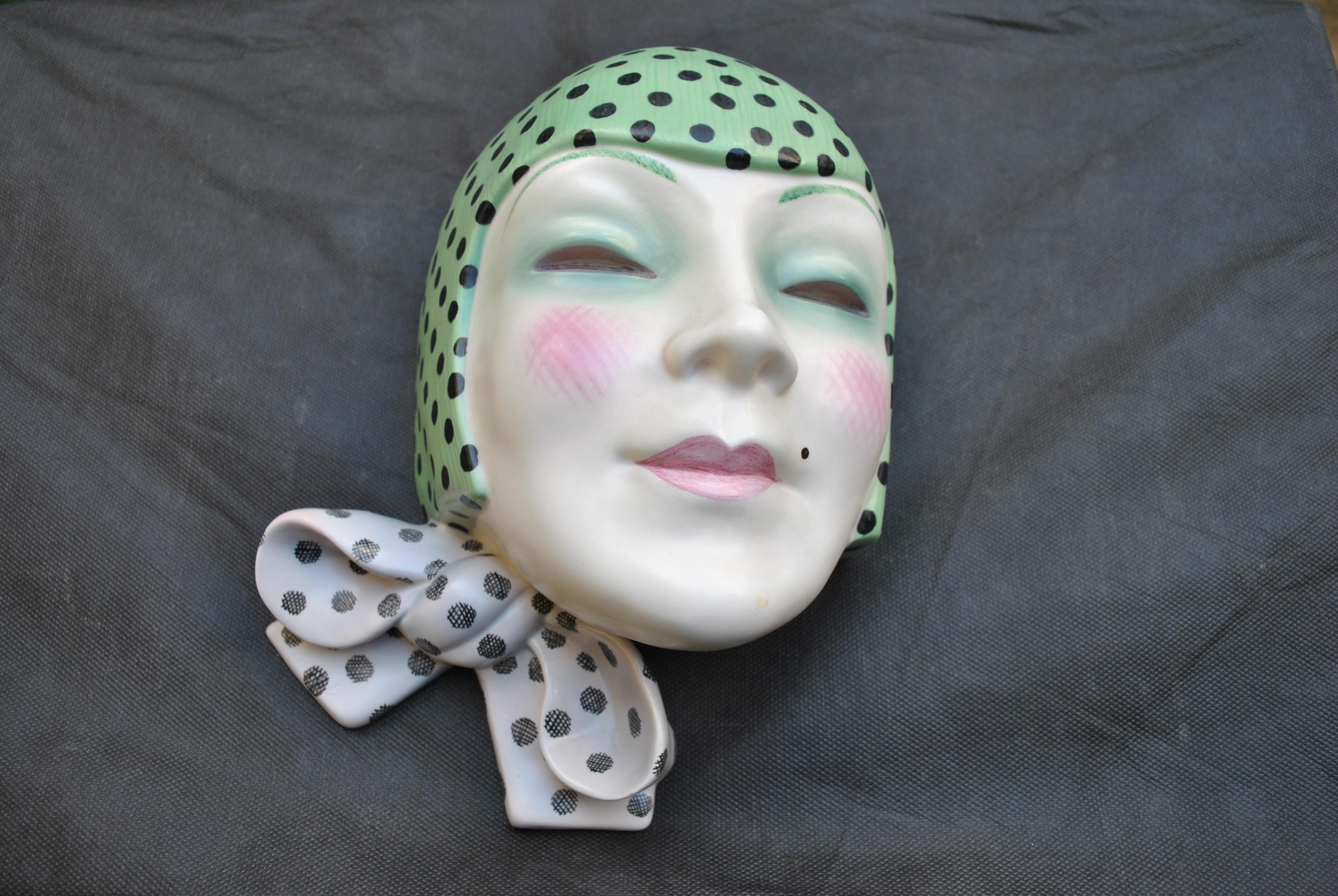 One of, if not the rarest Lenci wall mask designed by Helen Konig Scavini. The mask is called 'Maschera con nodo'. The mask is modelled as fashionable young woman in a spotted head scarf with large bow, in pure art déco style.
She has amazing hand