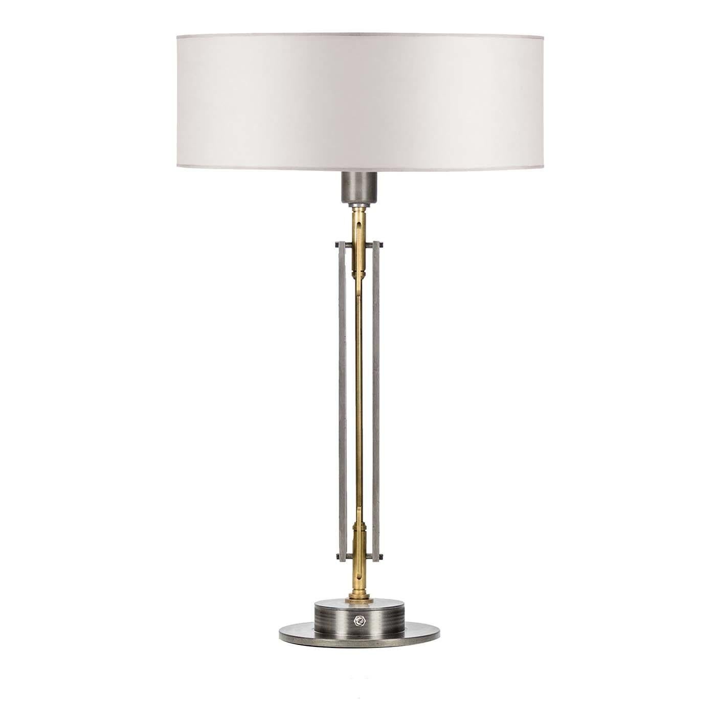 Featuring a sleek, modern design with a geometric silhouette and round base, this understated lamp brings a classic touch to any interior. The polished steel and brass of the structure lends a warm look that will suit any neutral color palette with
