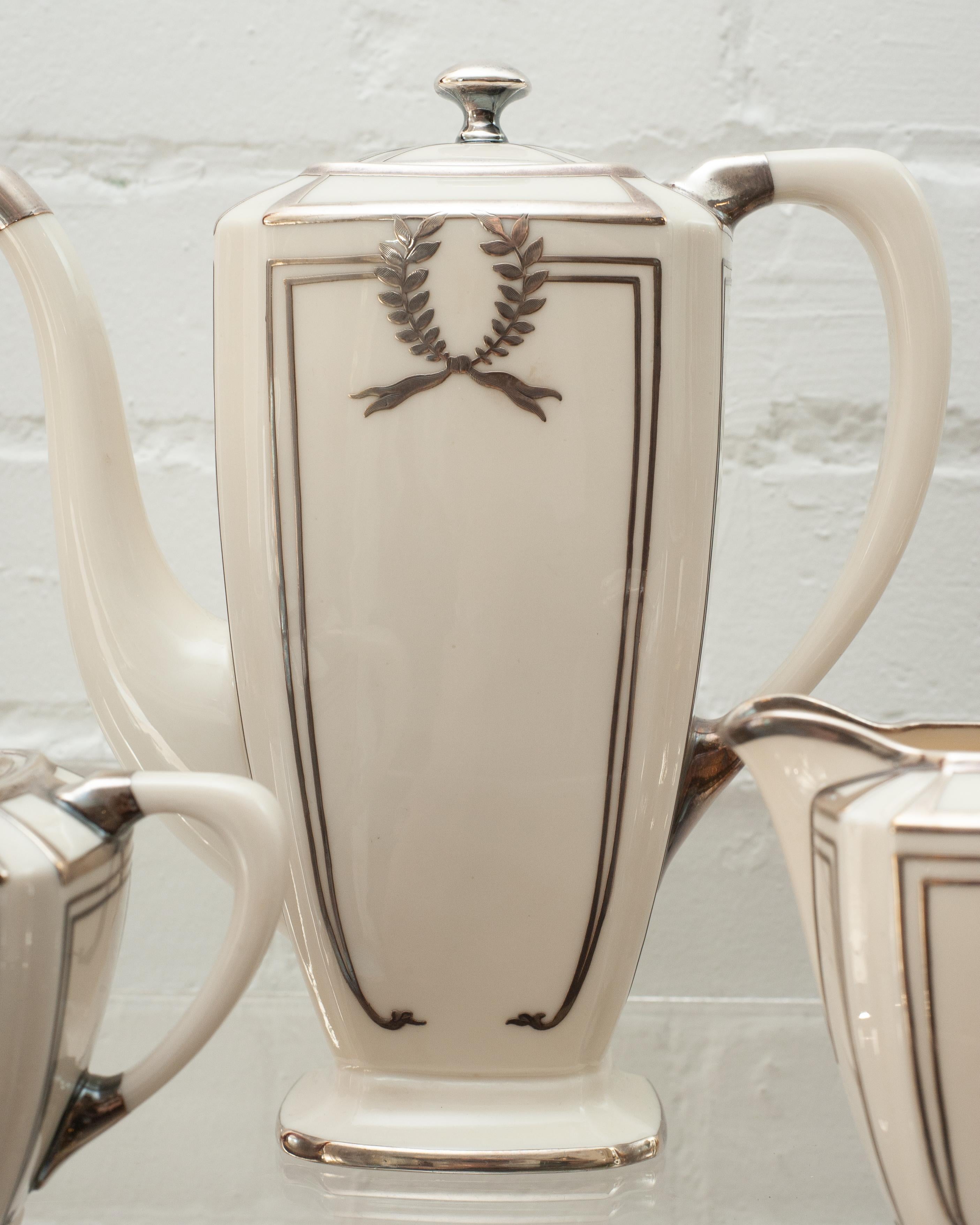 Invite your guests for tea and macaroons and impress them with this crème porcelain Lenox Art Deco coffee set with sterling silver details. Set includes one coffee pot, one creamer and one sugar bowl.