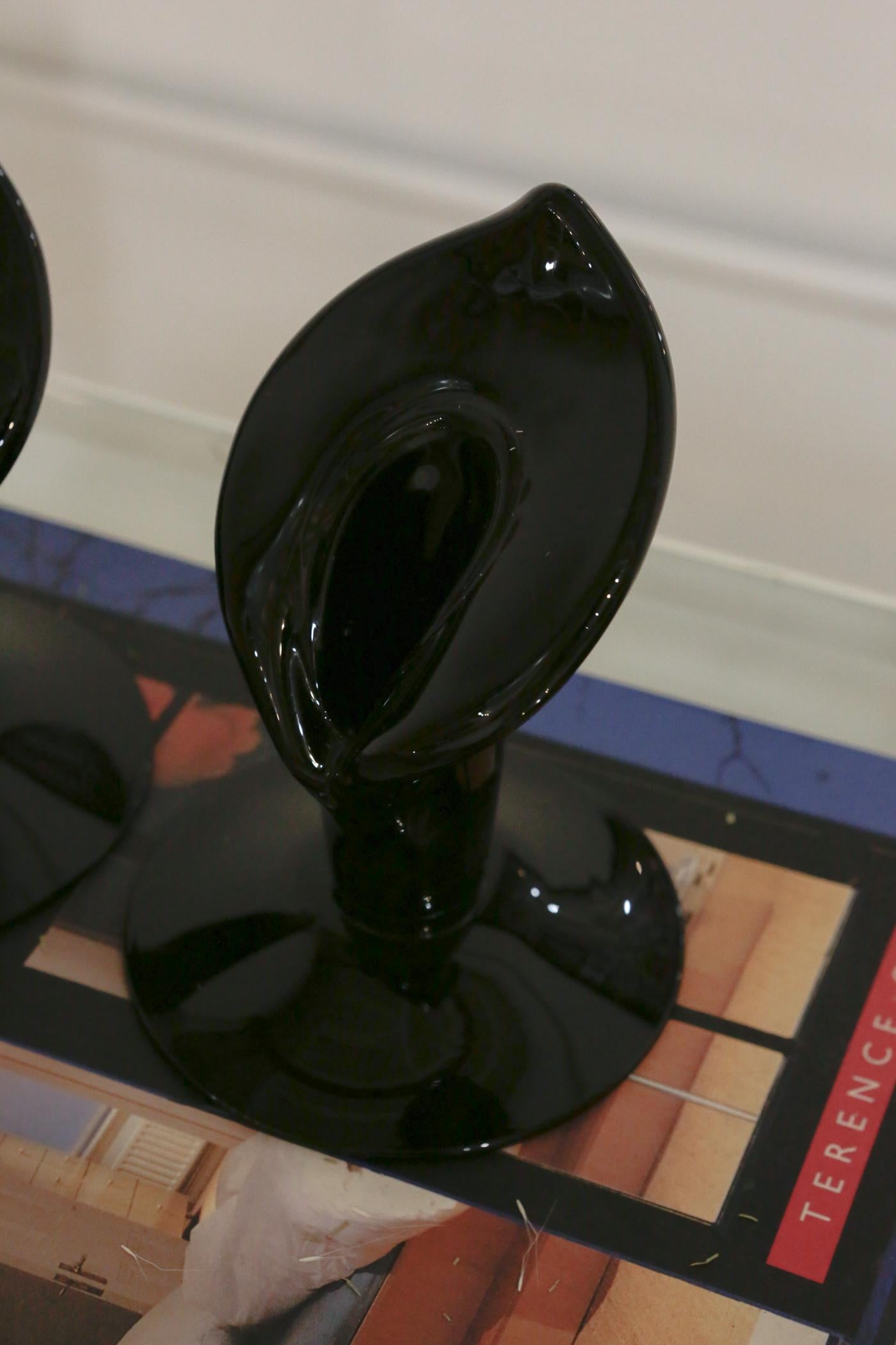 Lenox black glass candle holders, set of two. This elegant pair of candle stands feature a symmetrical and gracefully lily-shaped by Lenox. In mint condition with no chips. 

Measures: 6.5