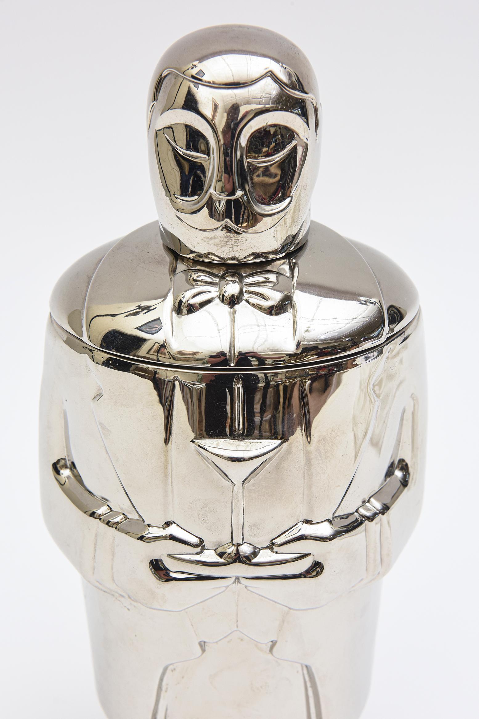 This delightful and whimsical chrome bartender martini shaker by Lenox is ready to mix your fabulous drinks. It is from the late 1990's and has an art deco inspired design. The all dressed up with bowtie bartender is holding the martini shaker close