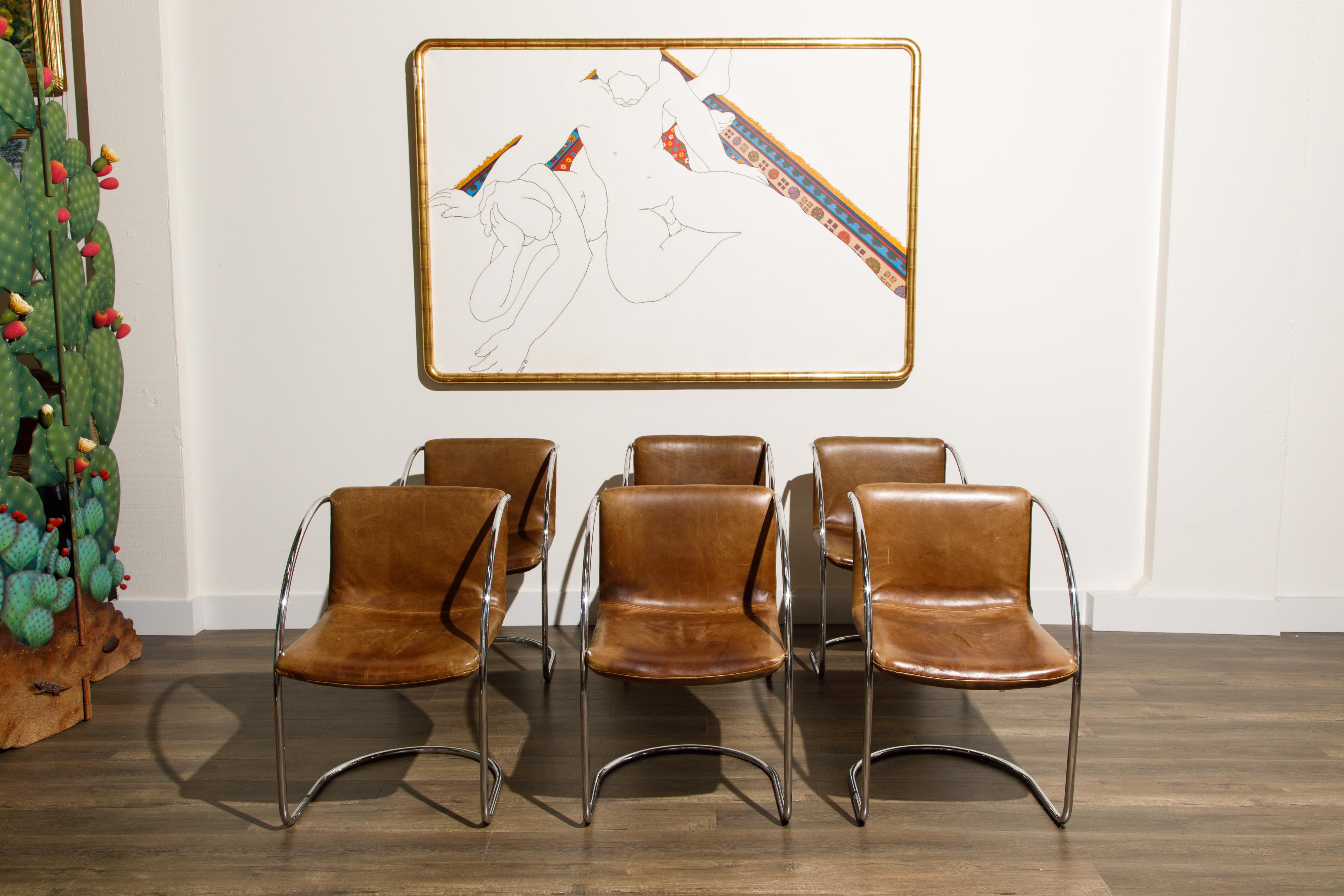 The age and patina on the thick leather of this set of six 'Lens' dining chairs by Giovanni Offredi for Saporiti Italia is so incredible and the bright clean tubular steel adds to the Italian 60s style. Designed in 1968, these armchairs were an