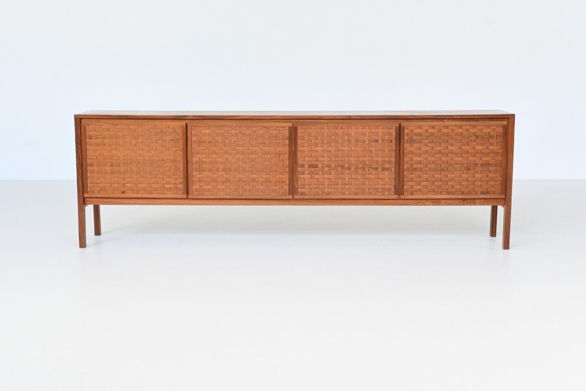 Stunning sideboard designed by Leo Bub for Bub Wertmöbel, Germany 1960. This beautiful symmetric cabinet is made in nicely grained rosewood. It has four doors with shelves behind and there are four white lacquered drawers behind a door. The doors