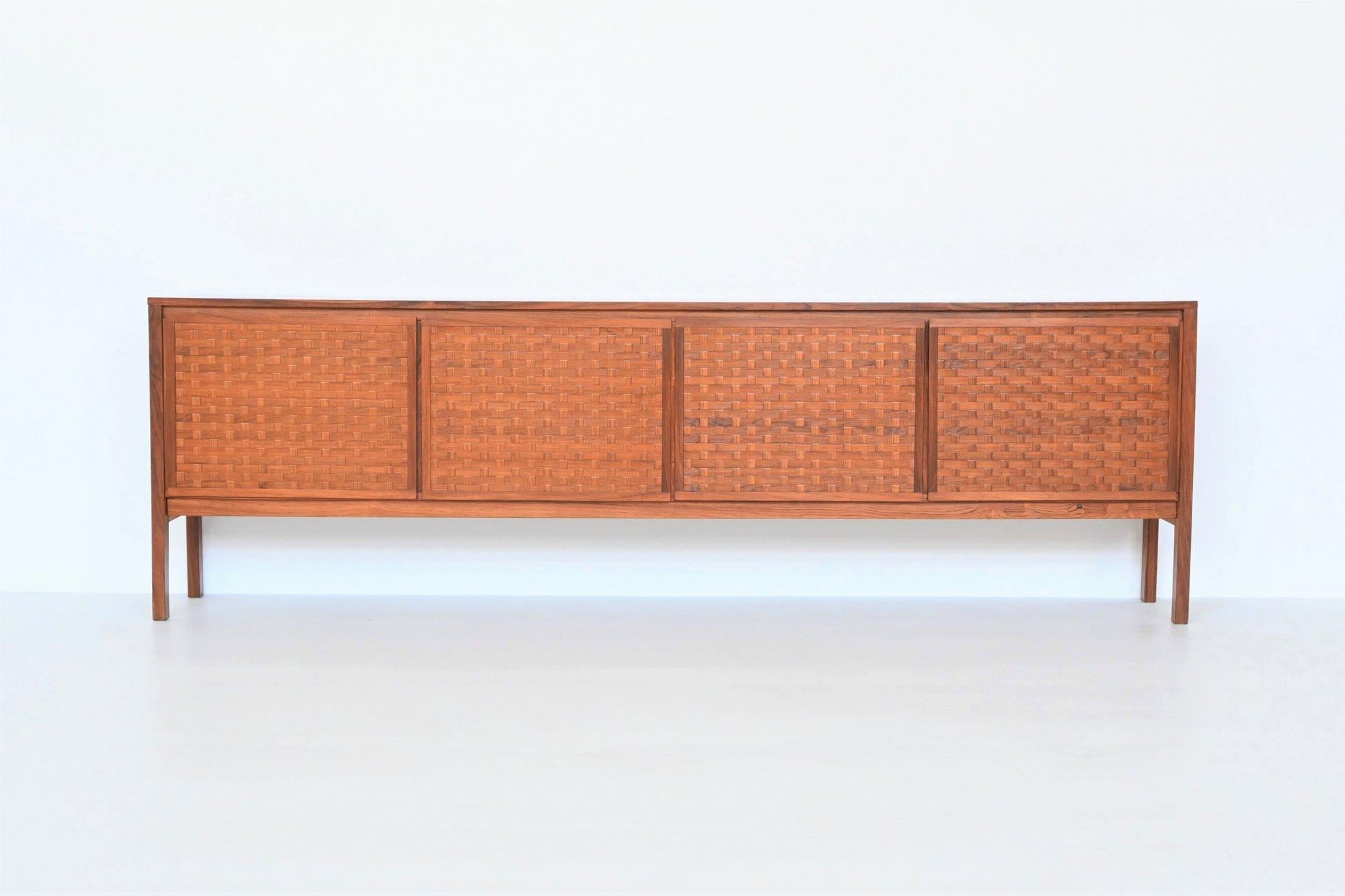 Stunning sideboard designed by Leo Bub for Bub Wertmöbel, Germany 1960. This beautiful symmetric cabinet is made in nicely grained rosewood. It has four doors with shelves behind and there are four white lacquered drawers behind a door. The doors