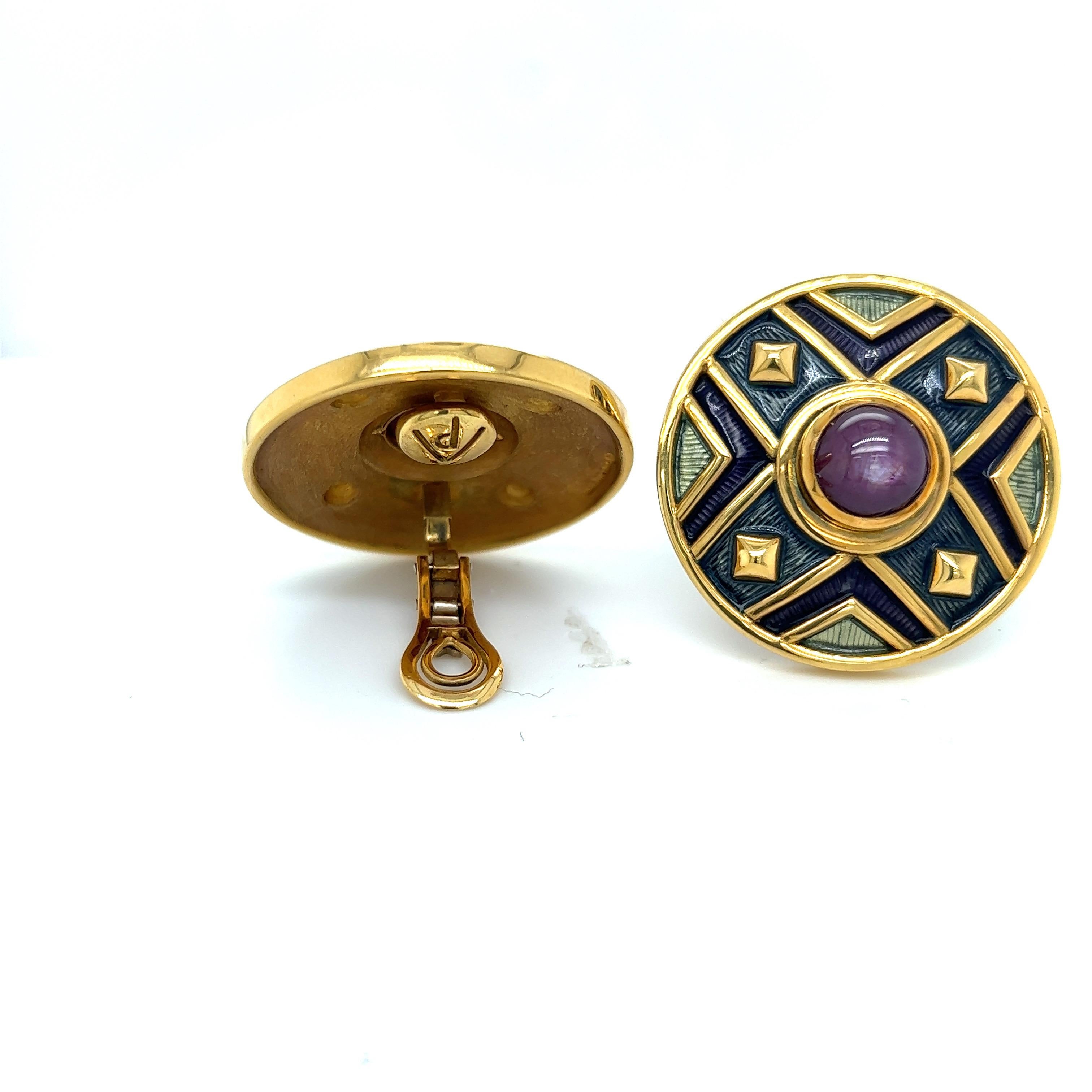These 18 karat yellow gold earrings are the perfect example of de Vroomens iconic style. The large cabochon star ruby centers are offset with beautiful guilloche enamel in a neutral grey , green and purple color, along with yellow gold details. They