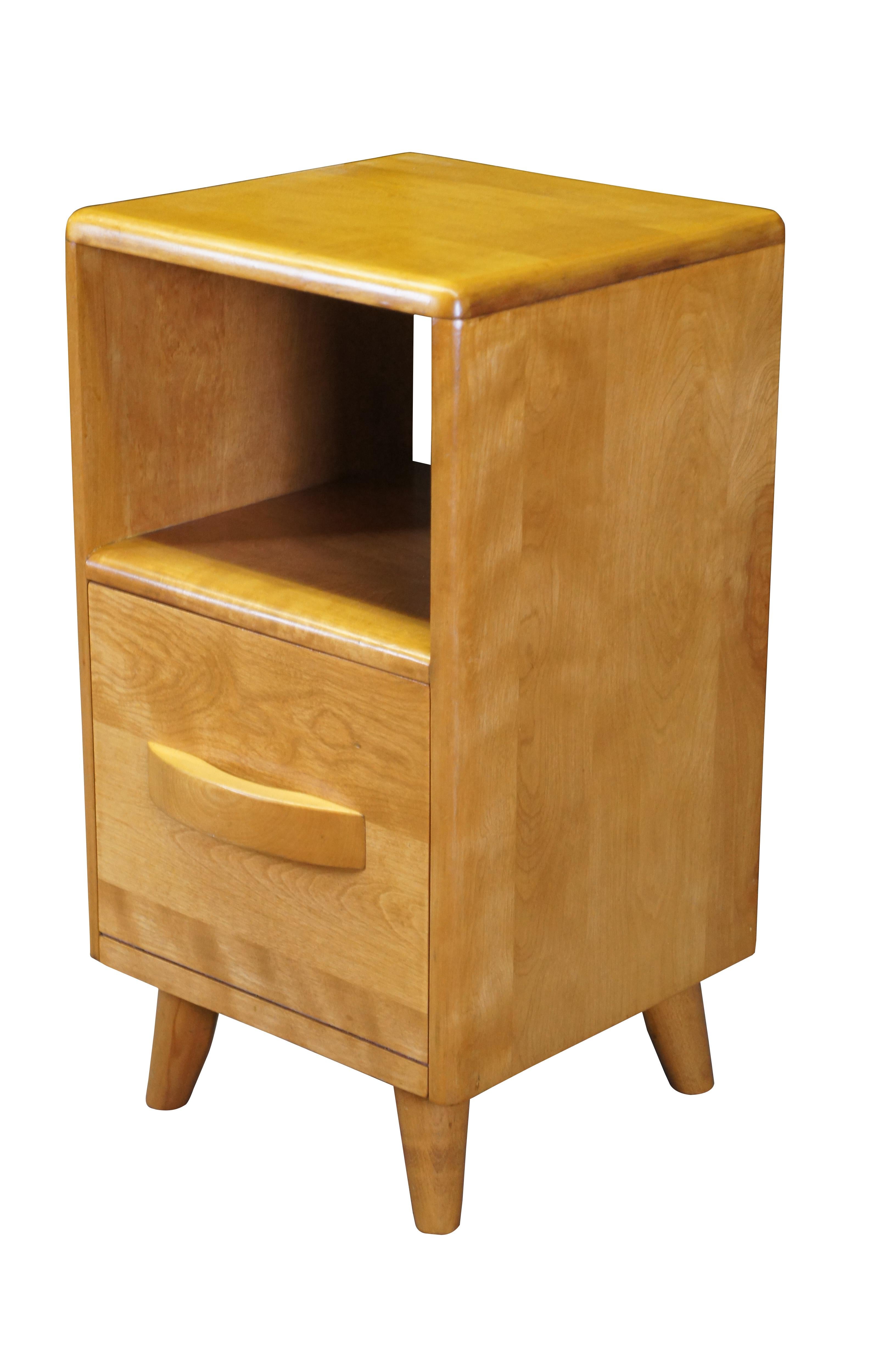 Mid century modern circa 1940s Leo Jiranek for Heywood Wakefield nightstand.  Made of maple (champagne) featuring a two tiered design with cubby / shelf and drop front cabinet over tapered legs.

Dimensions:
14